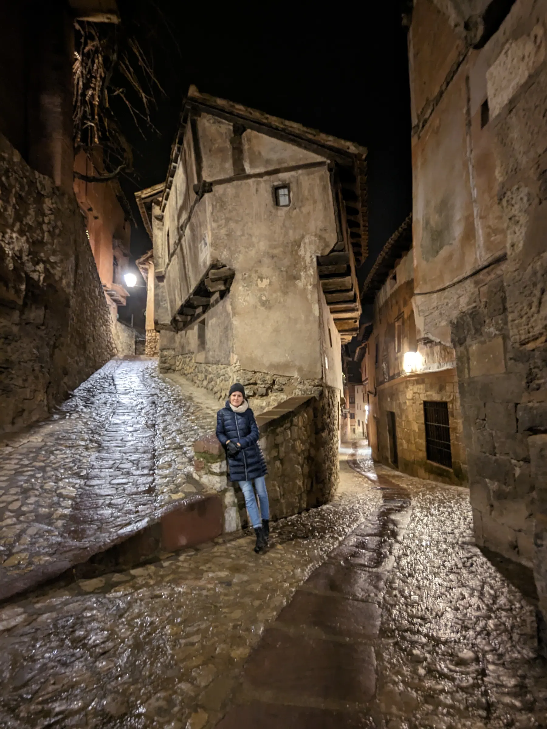 Zane standing before the distinctively crooked Casa de la Julianeta on a quiet cobblestone corner at night