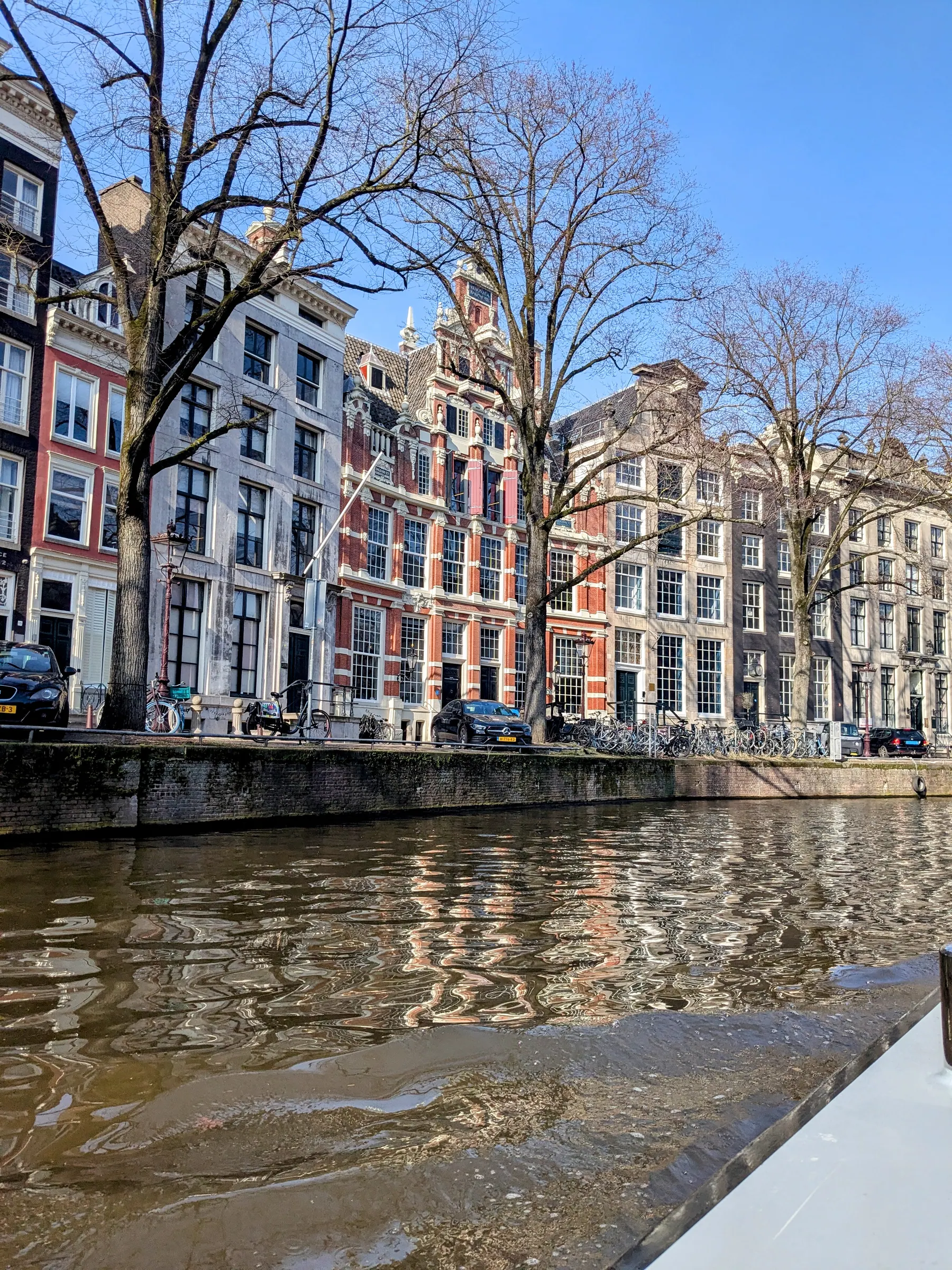 Sunny canal houses reflected in Amsterdam canal water