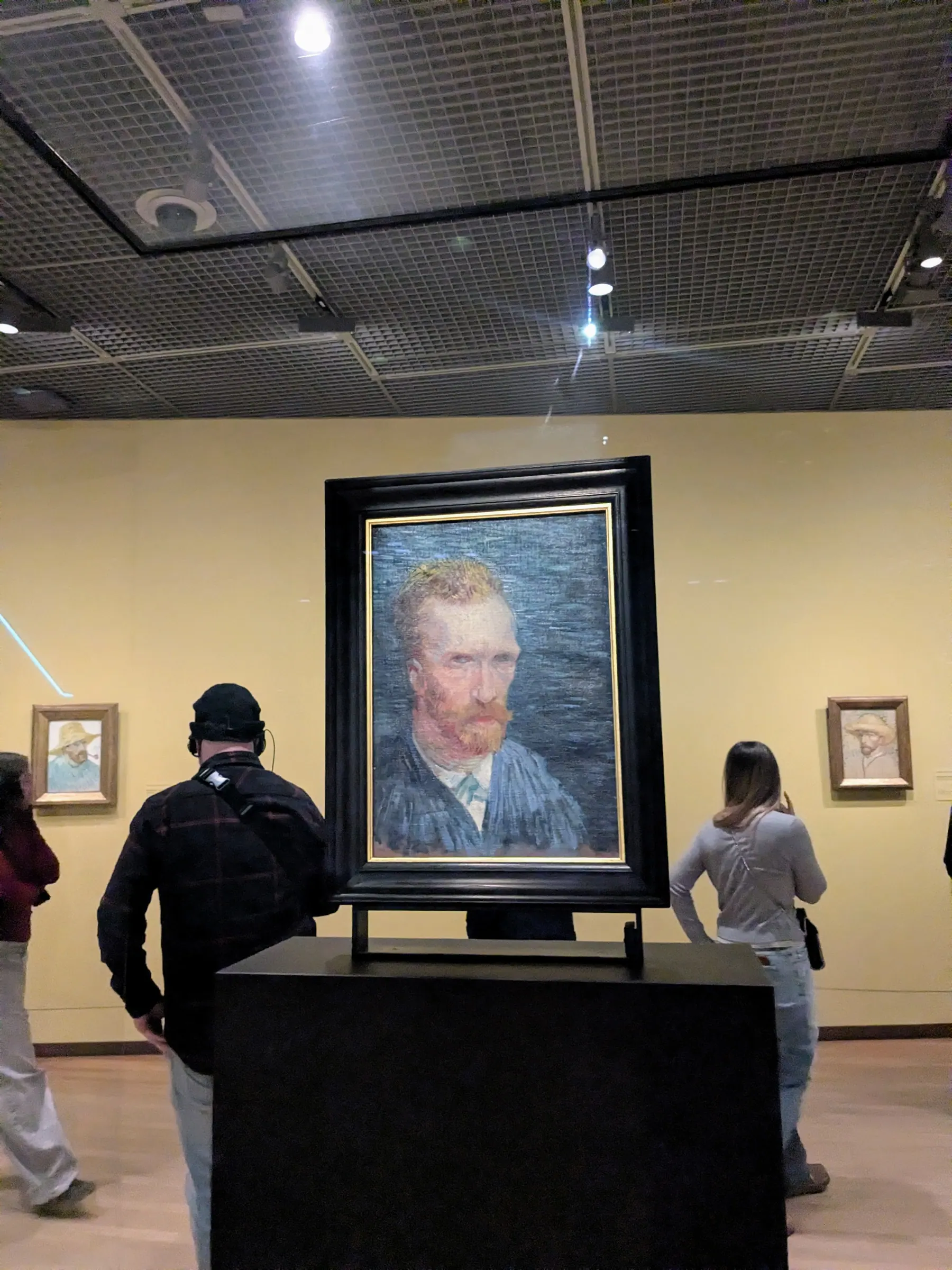 Visitors looking at a Van Gogh self portrait inside the Van Gogh Museum