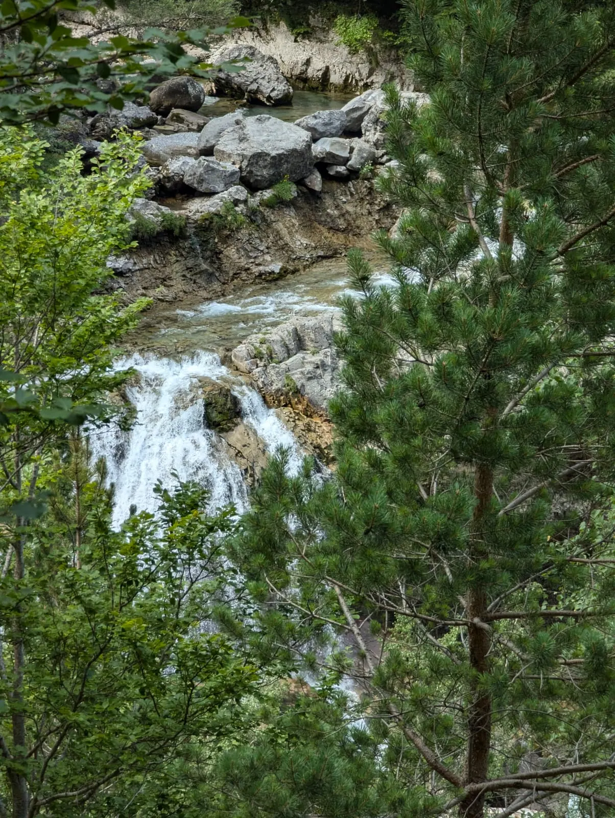 A waterfall dropping through a high rocky gorge in the Aragonese Pyrenees