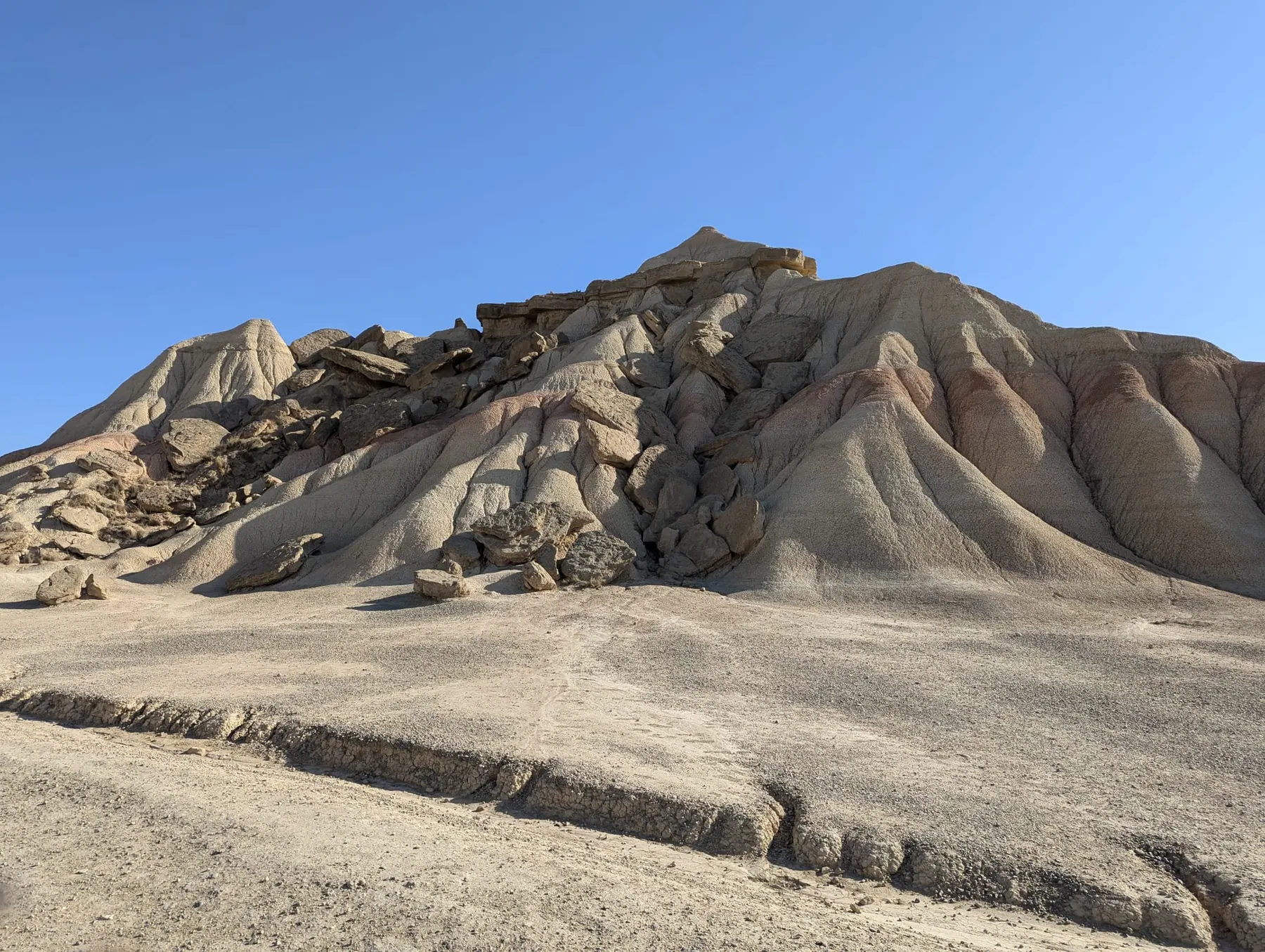 Close view of pale eroded clay slopes and broken rock in Bardenas Reales