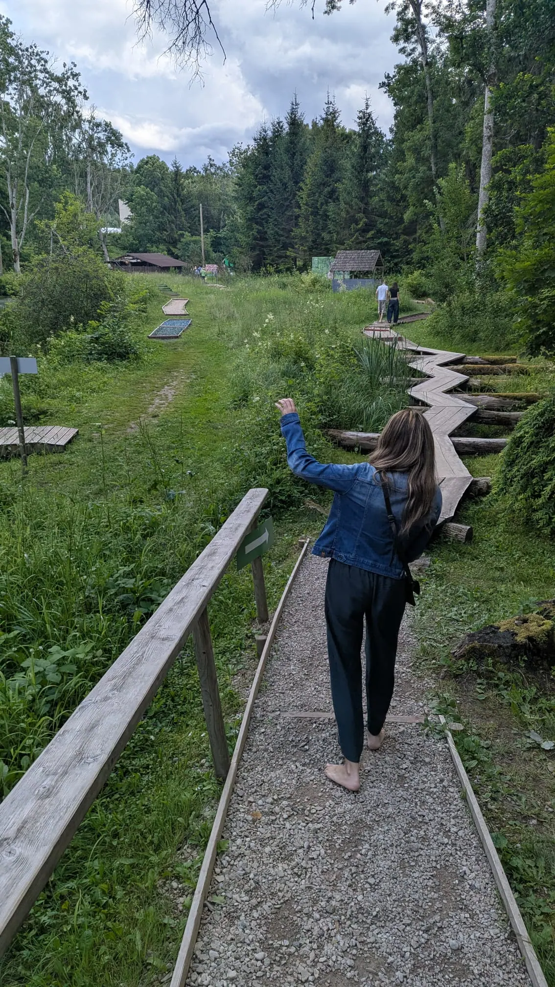A visitor walking barefoot over a gravel section of the trail