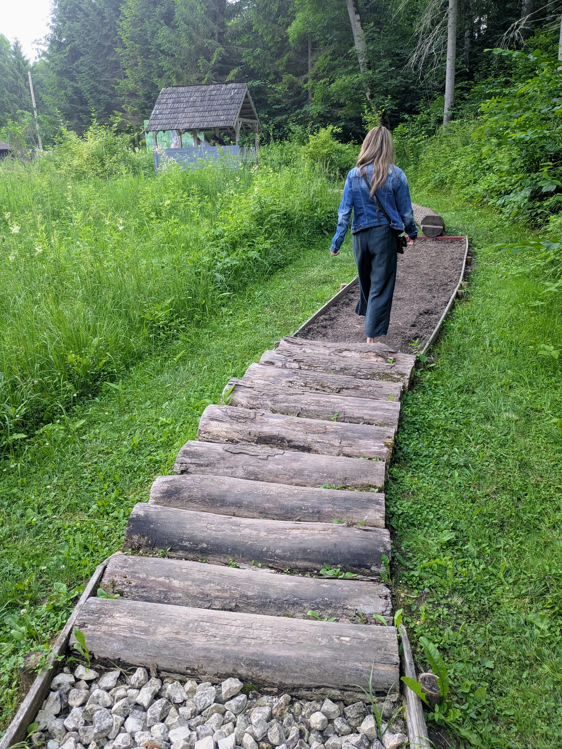 A visitor walking barefoot along the Valguma Pasaule trail