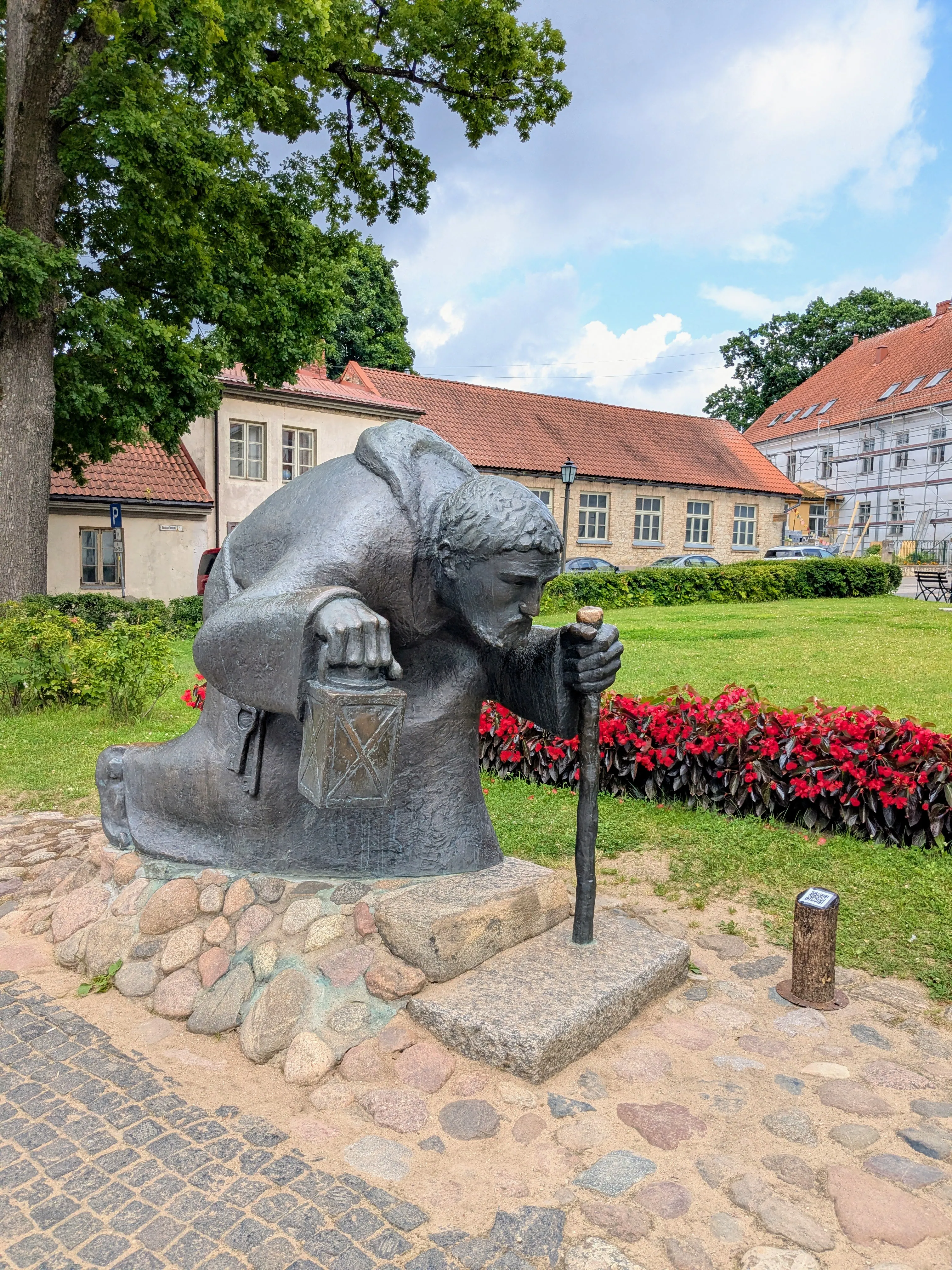 Old Man Time statue holding a candle lantern near Cēsis Castle