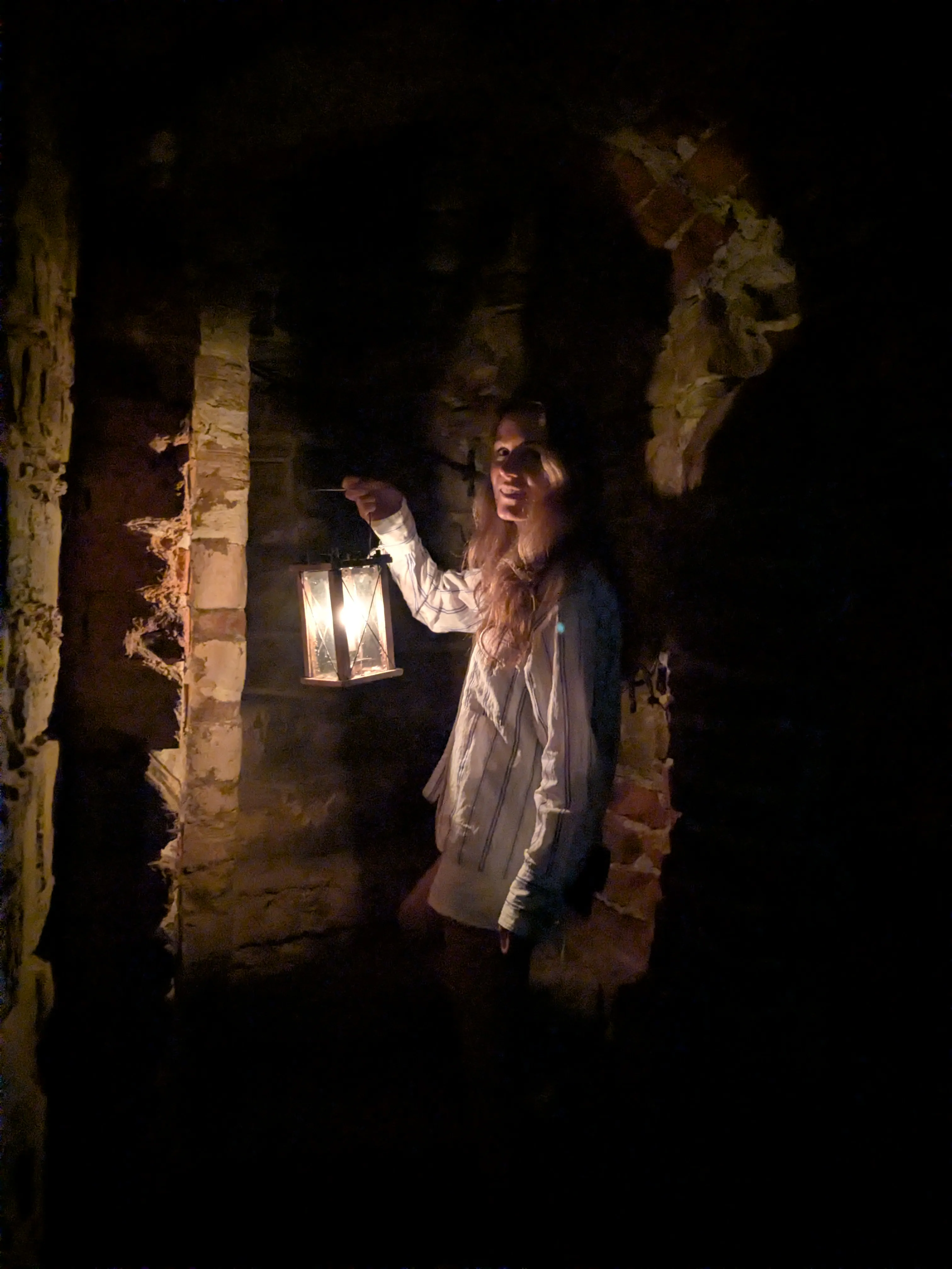 A candle lantern shining inside the dark castle ruins