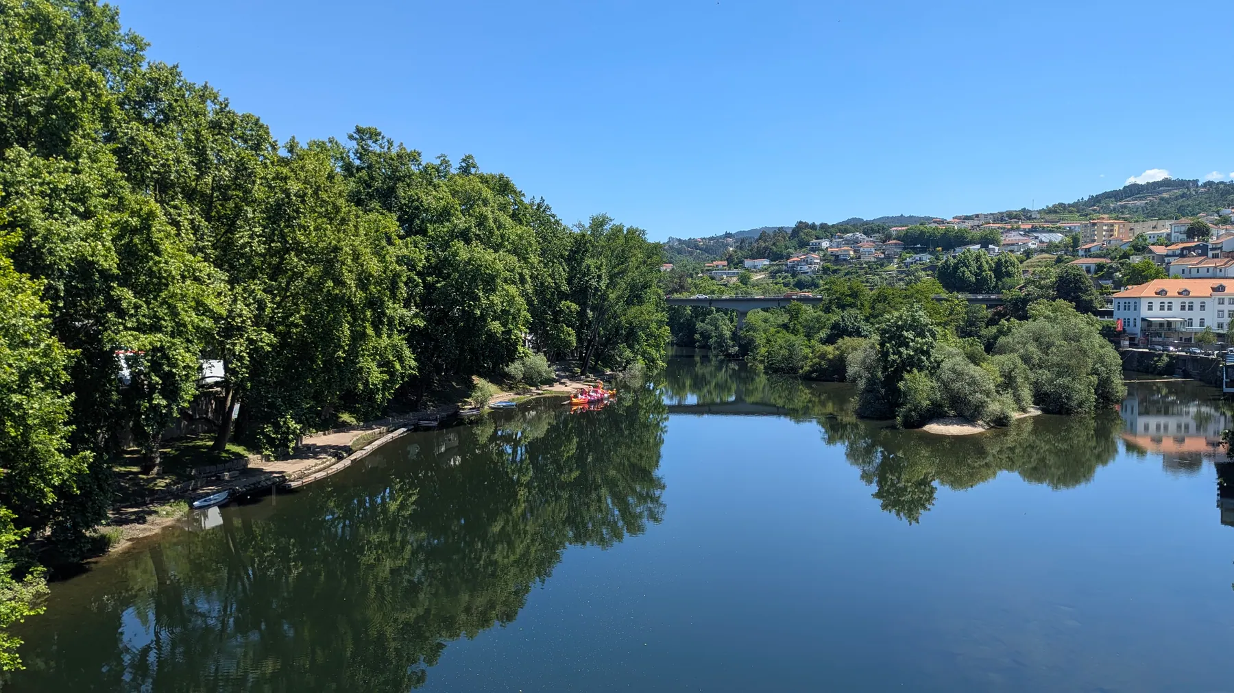 A calm river view in Amarante with trees reflected in the water
