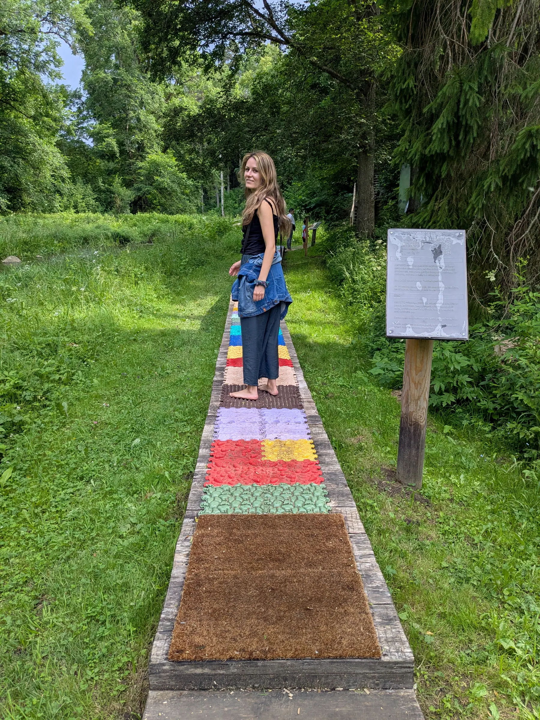 A barefoot trail crossing a forest path at Valguma Pasaule