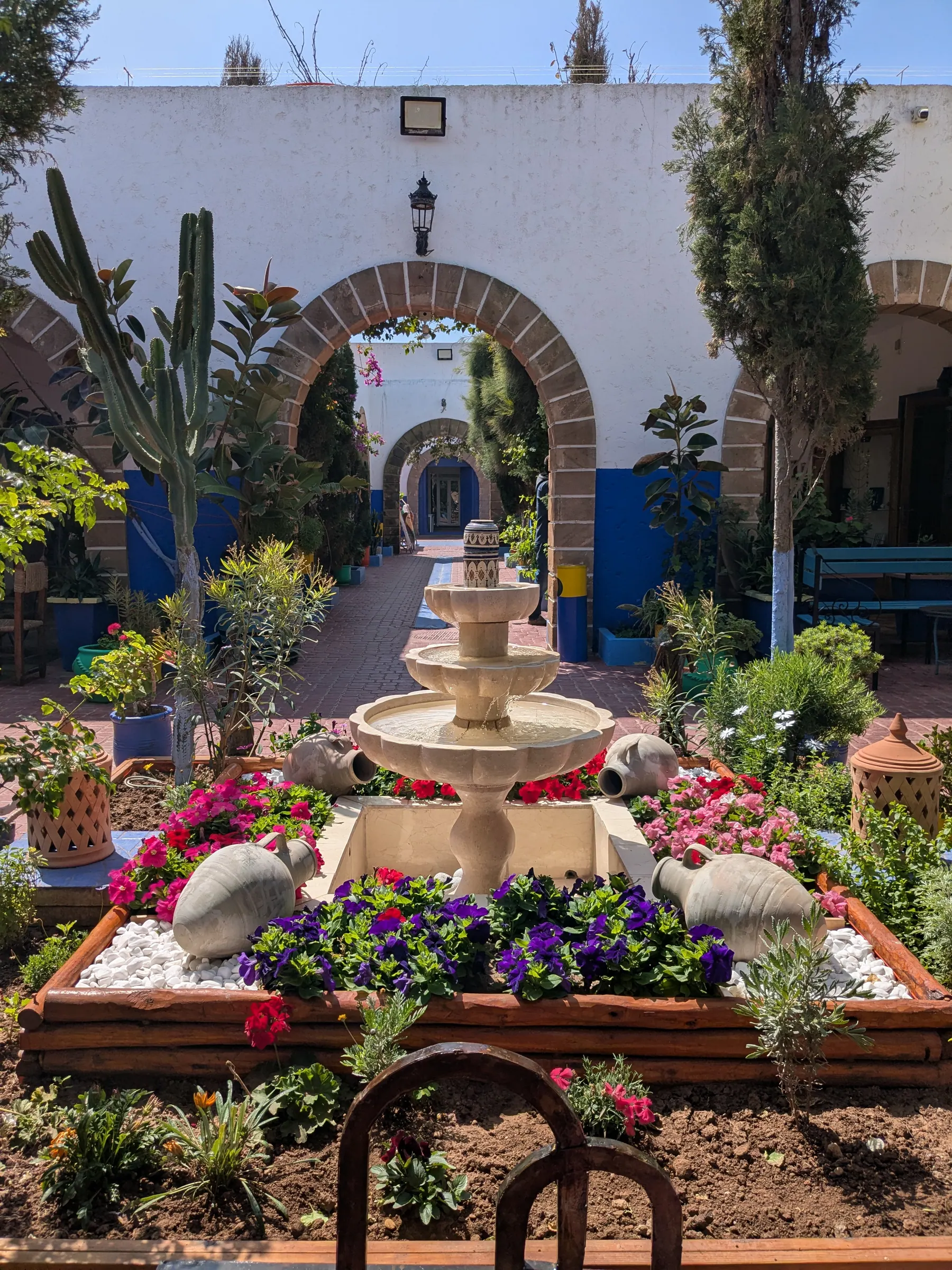 A fountain and flowerbeds inside Complexe Commercial Al Aswar in Essaouira