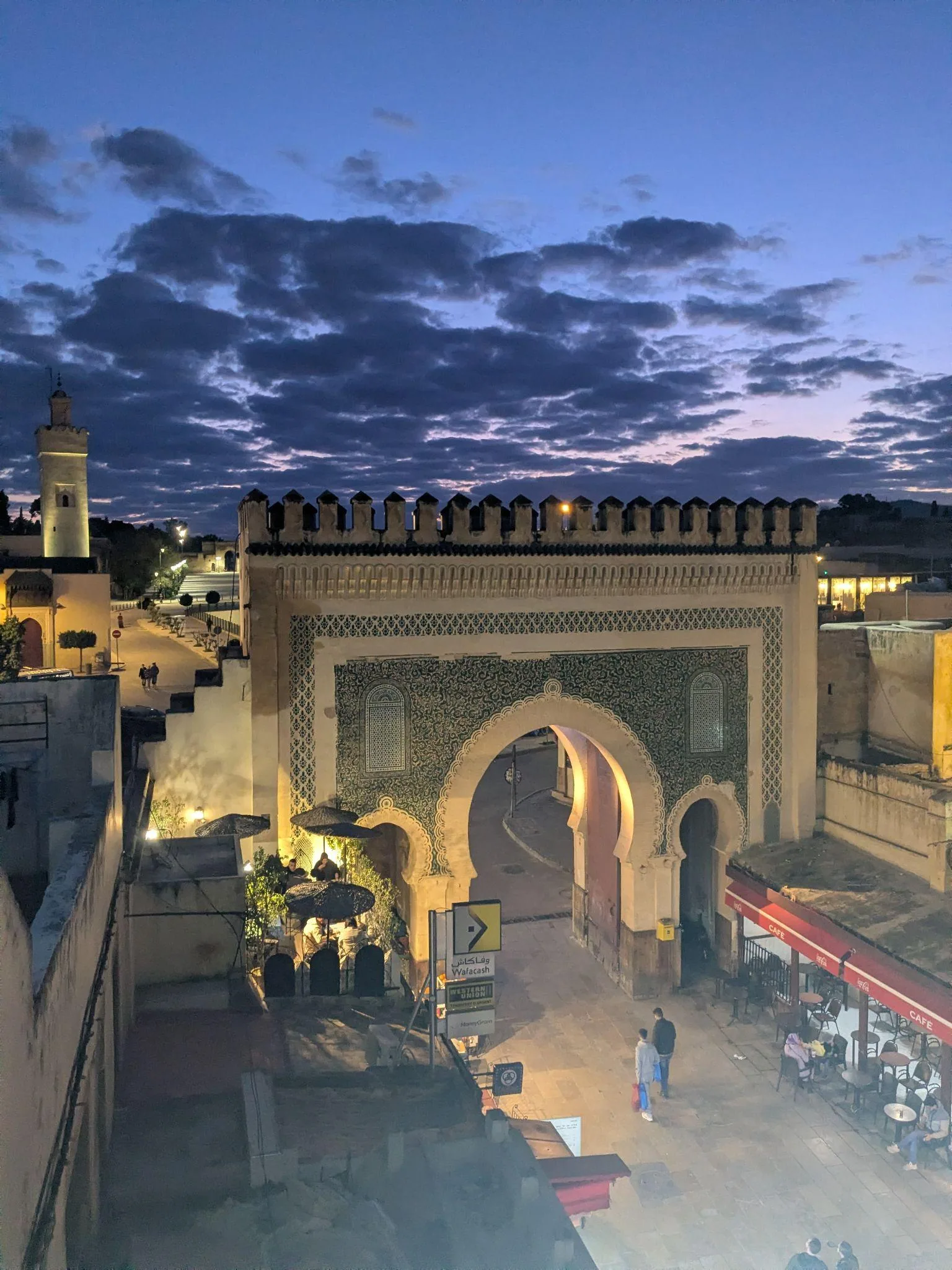 Bab Boujloud in Fez glowing after sunset from a rooftop cafe