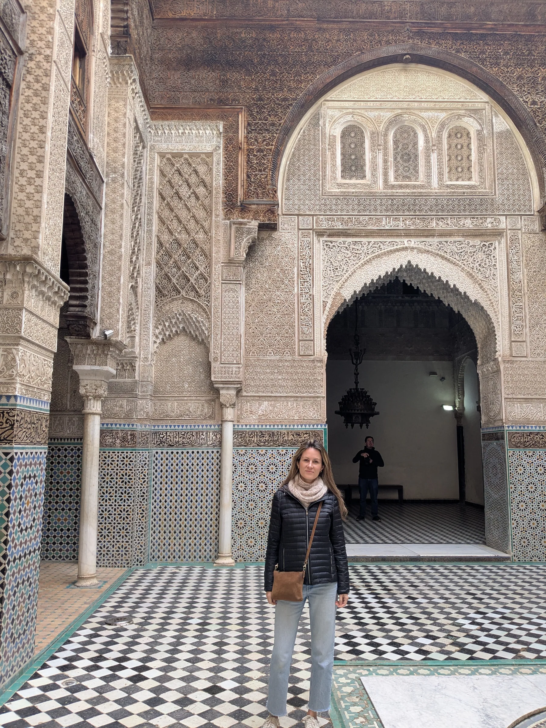 A traveler standing in the courtyard of Al Attarine Madrasa in Fez