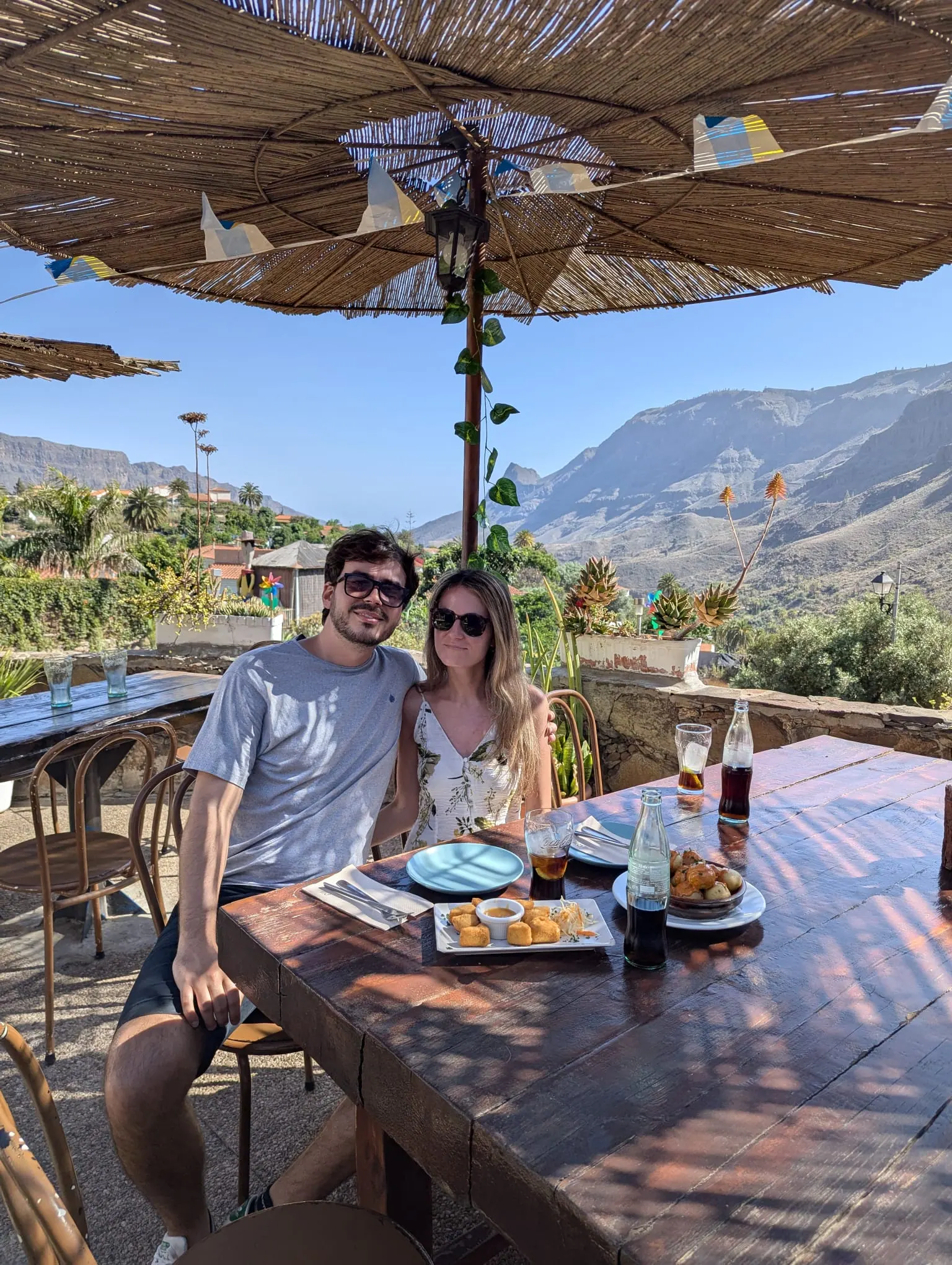 A couple sitting at an outdoor table with mountain views at Restaurante El Albaricoque near Fataga