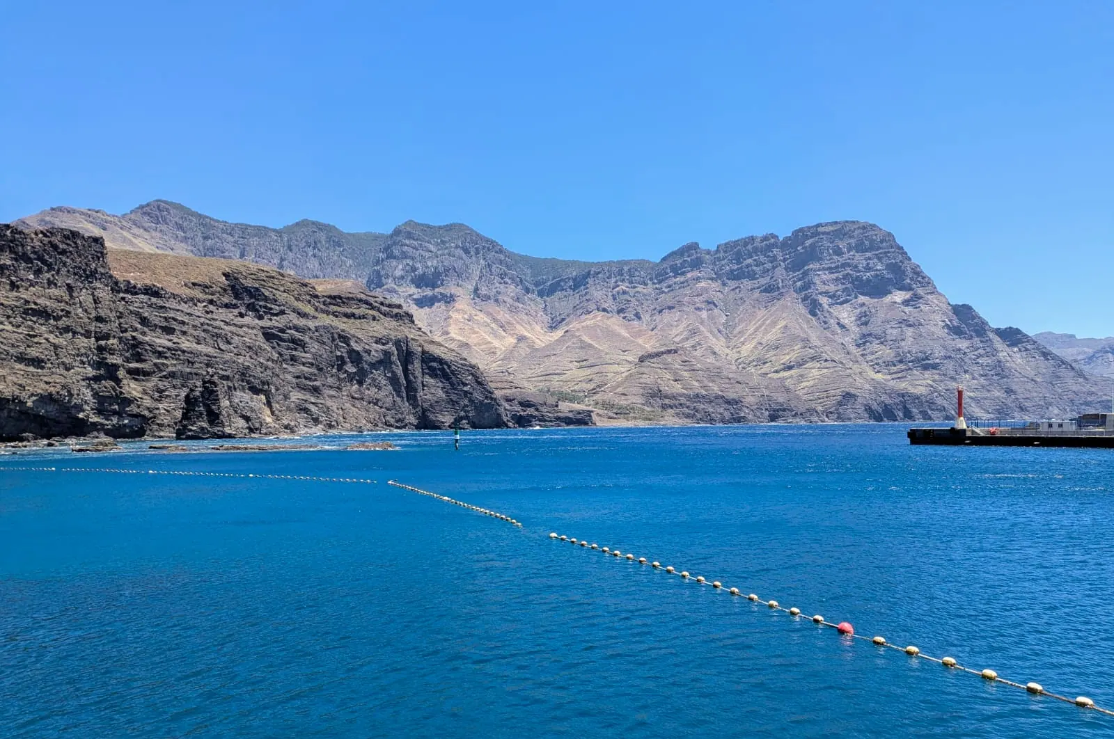 Clear blue water and volcanic cliffs along the coast at Agaete