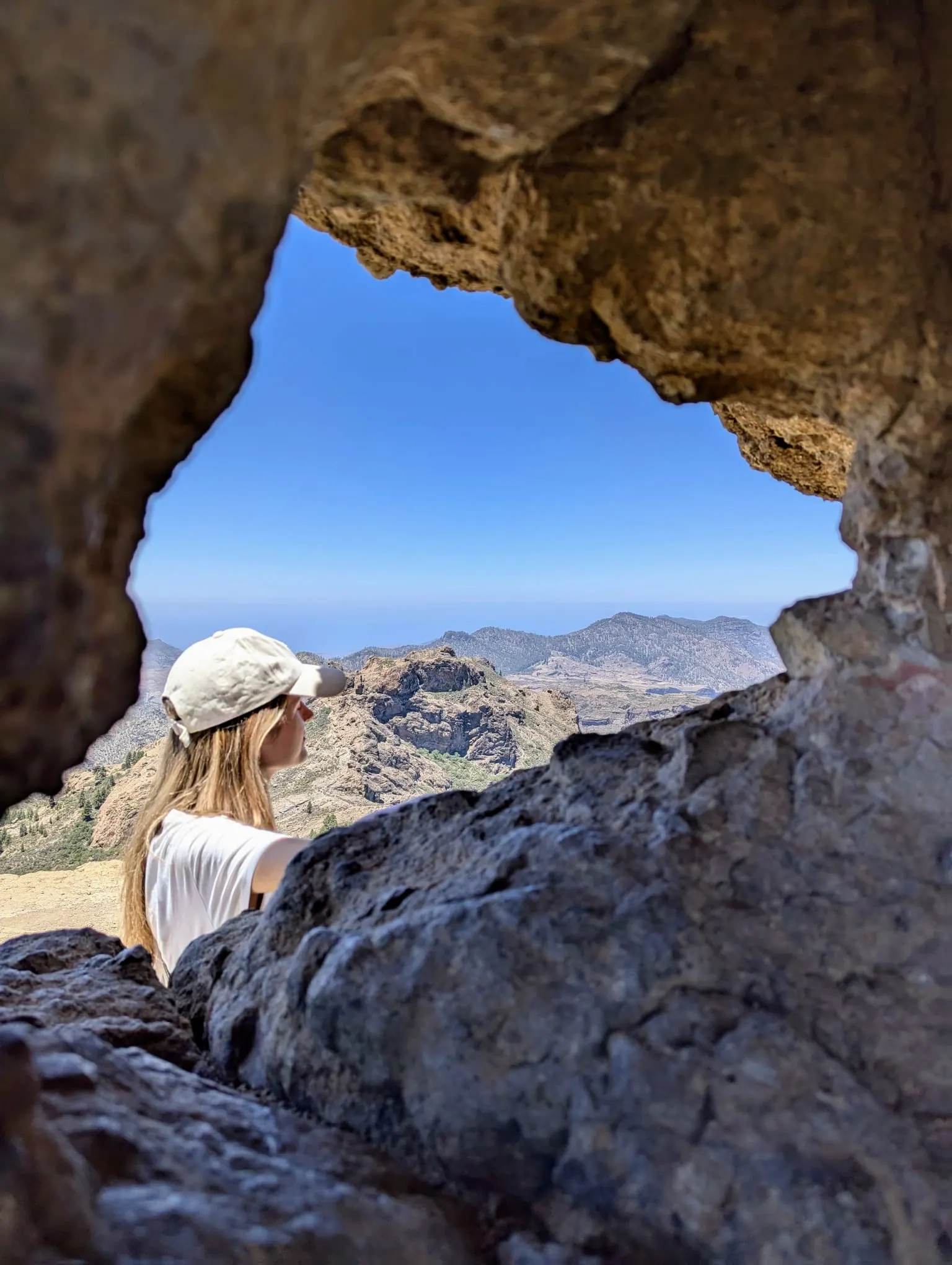 A traveller looking across the central mountains from the Roque Nublo trail