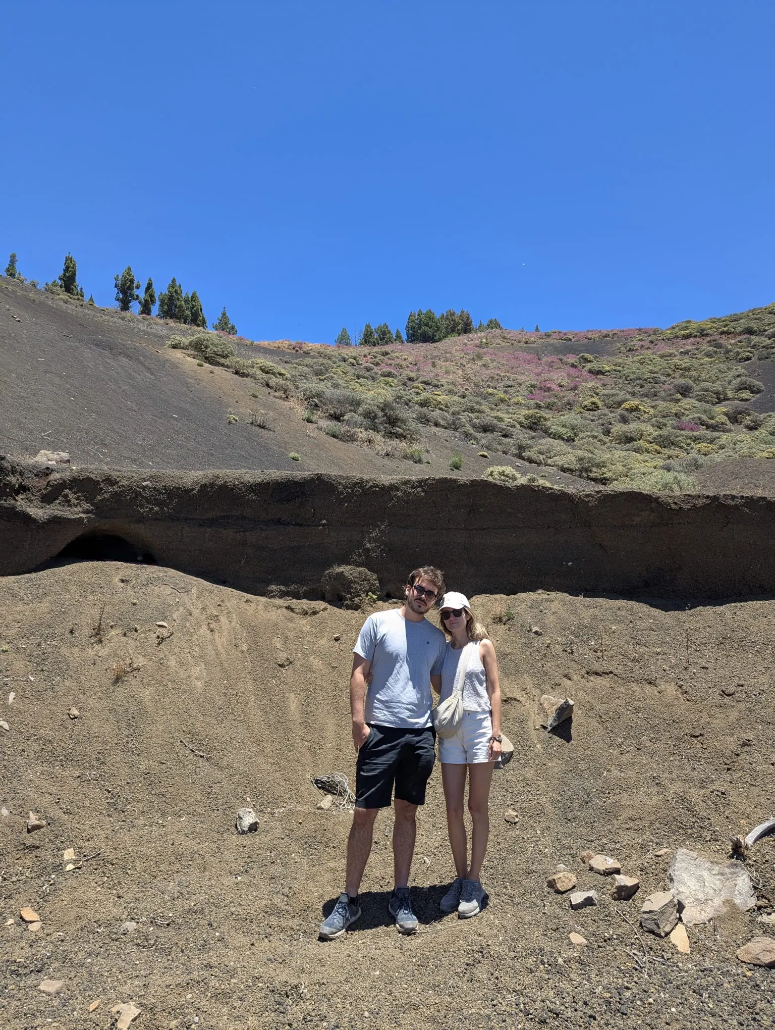 Visitors standing beside weathered volcanic formations in the western highlands
