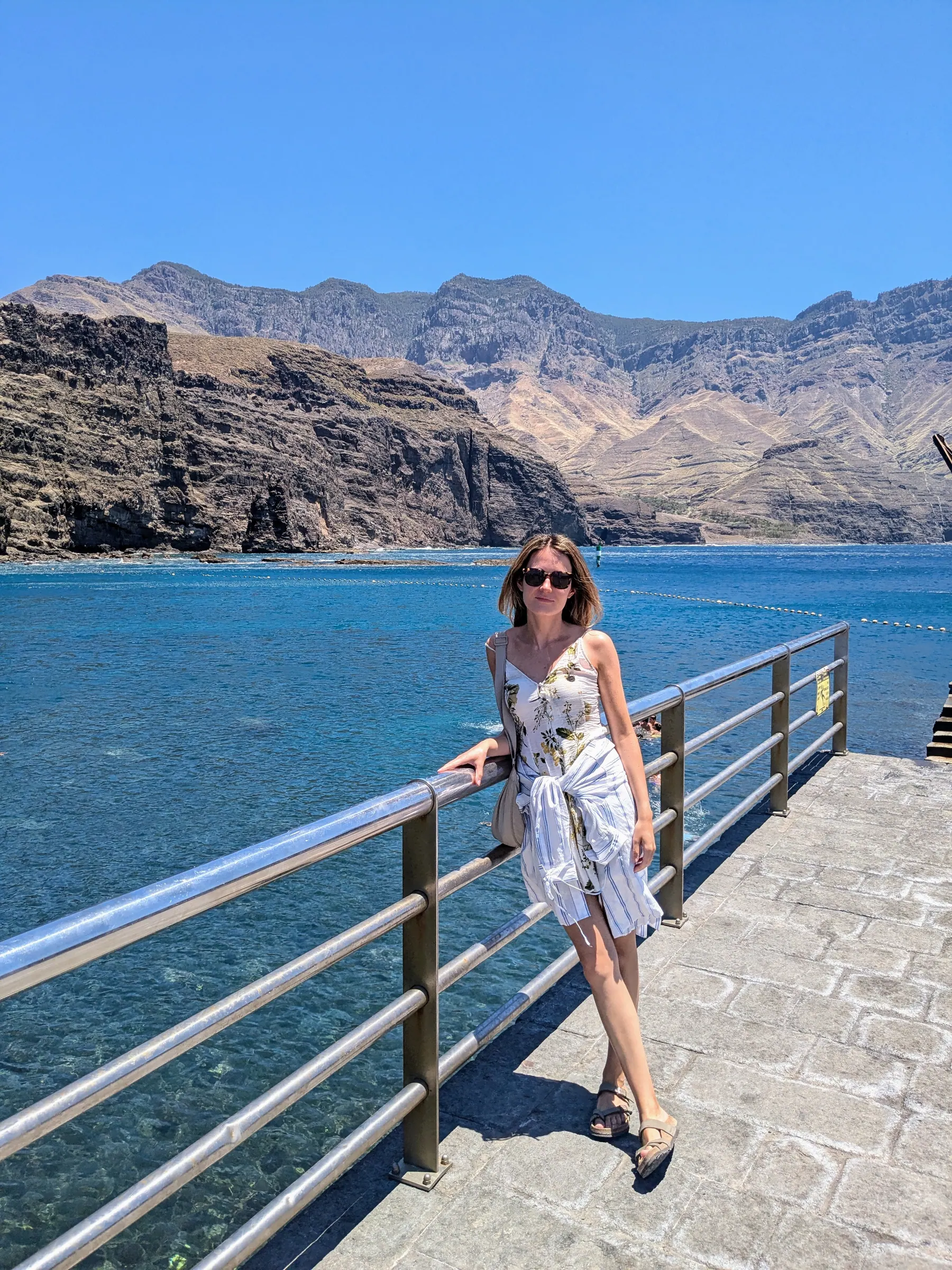 A traveller beside the sea and volcanic cliffs at Agaete harbour