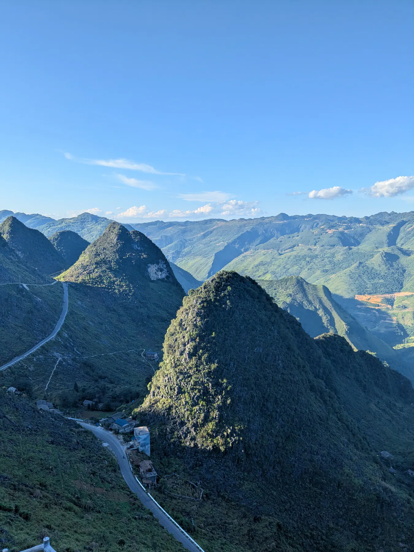 A pointed limestone mountain above winding roads and the deep valley at Ma Pi Leng