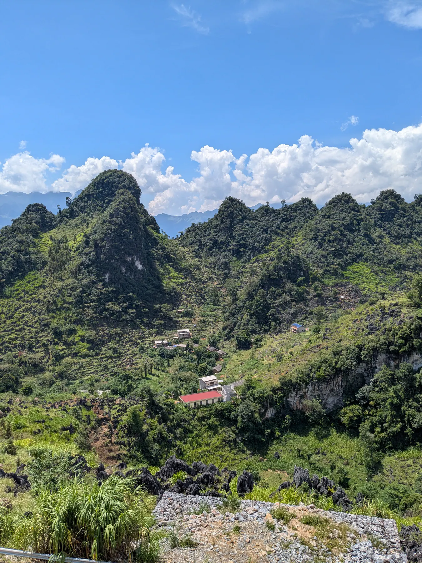 Angular limestone hills with small buildings and patches of cultivation around Lung Phin