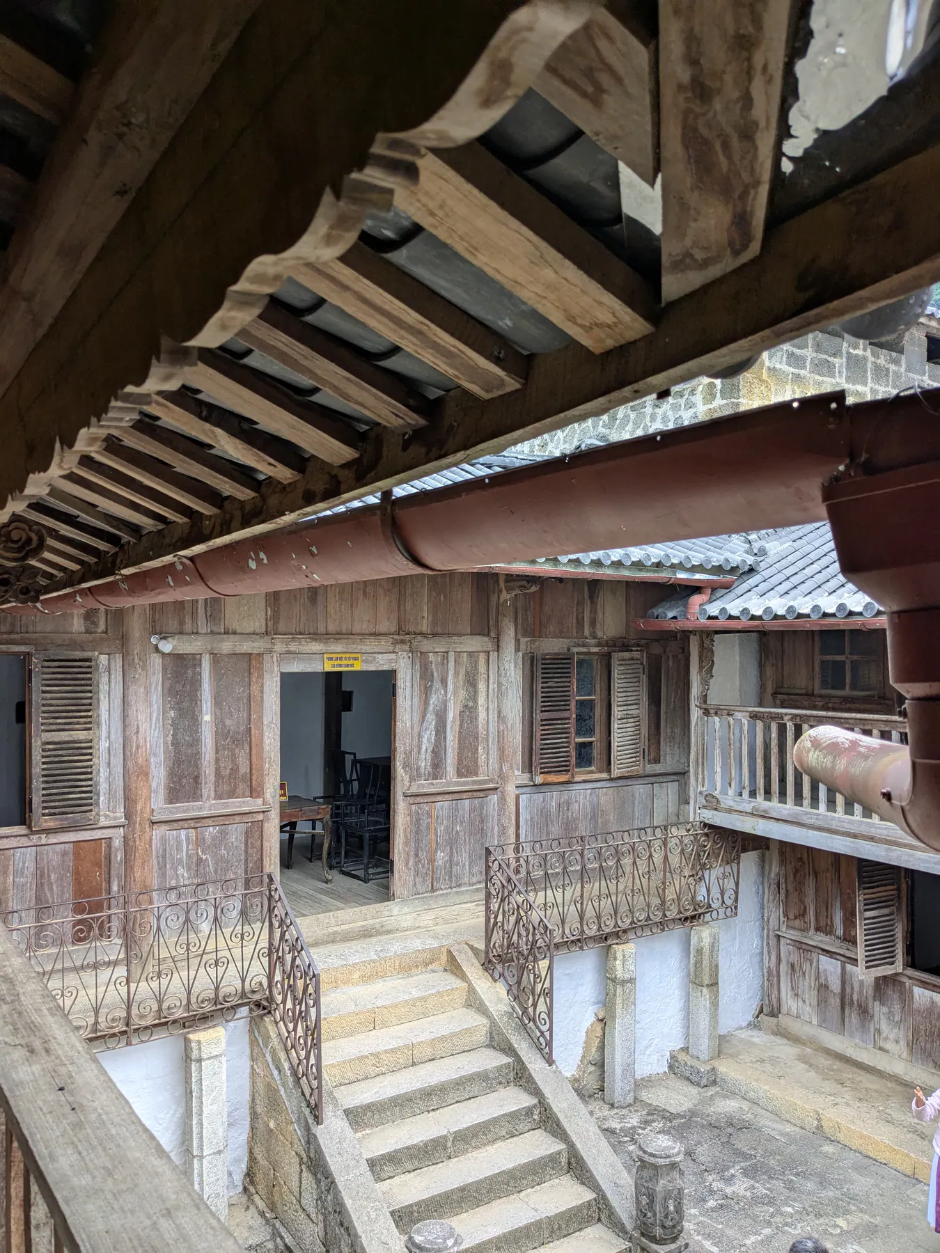 Wooden upper galleries and tiled roofs surrounding an inner courtyard at the Hmong King's palace
