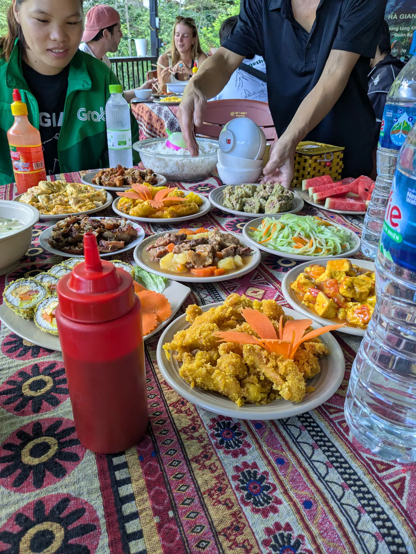 A table covered with bowls of rice, vegetables and shared Vietnamese dishes at the first day's lunch stop