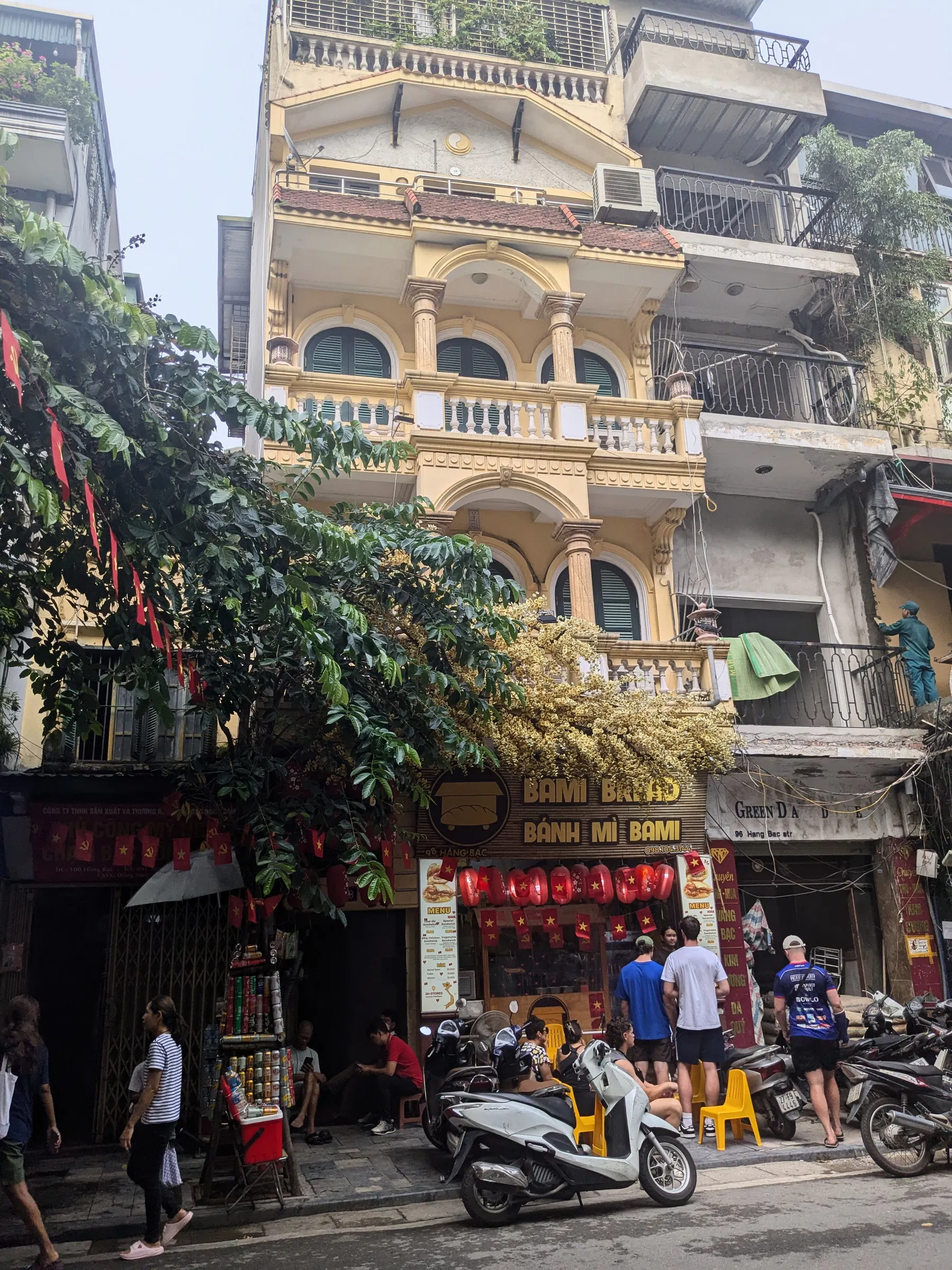 Red stools and street-food tables beneath trees in Hanoi's Old Quarter