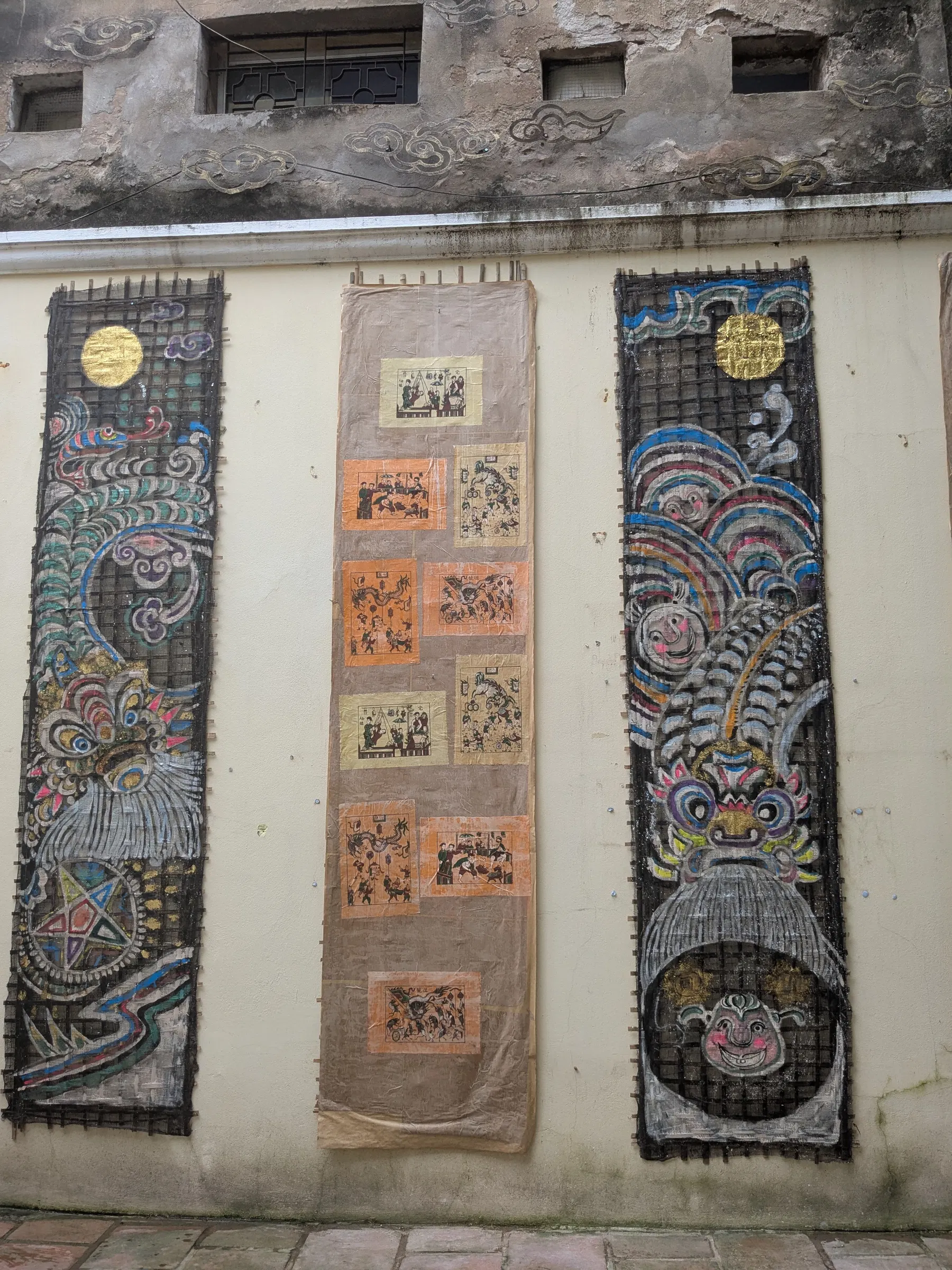 Decorated tiled doors and painted guardian motifs at a Hanoi temple