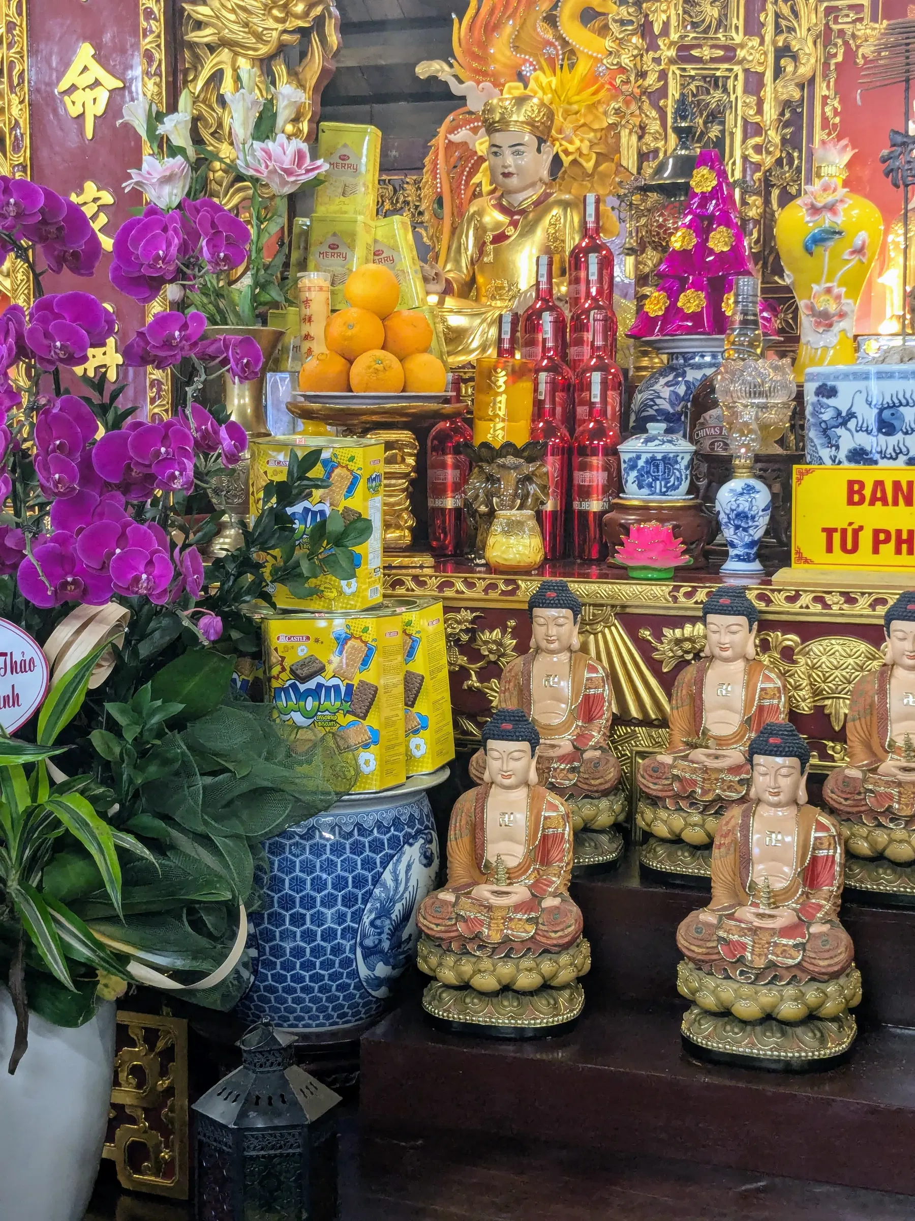 A richly decorated Buddhist shrine with flowers and fruit offerings