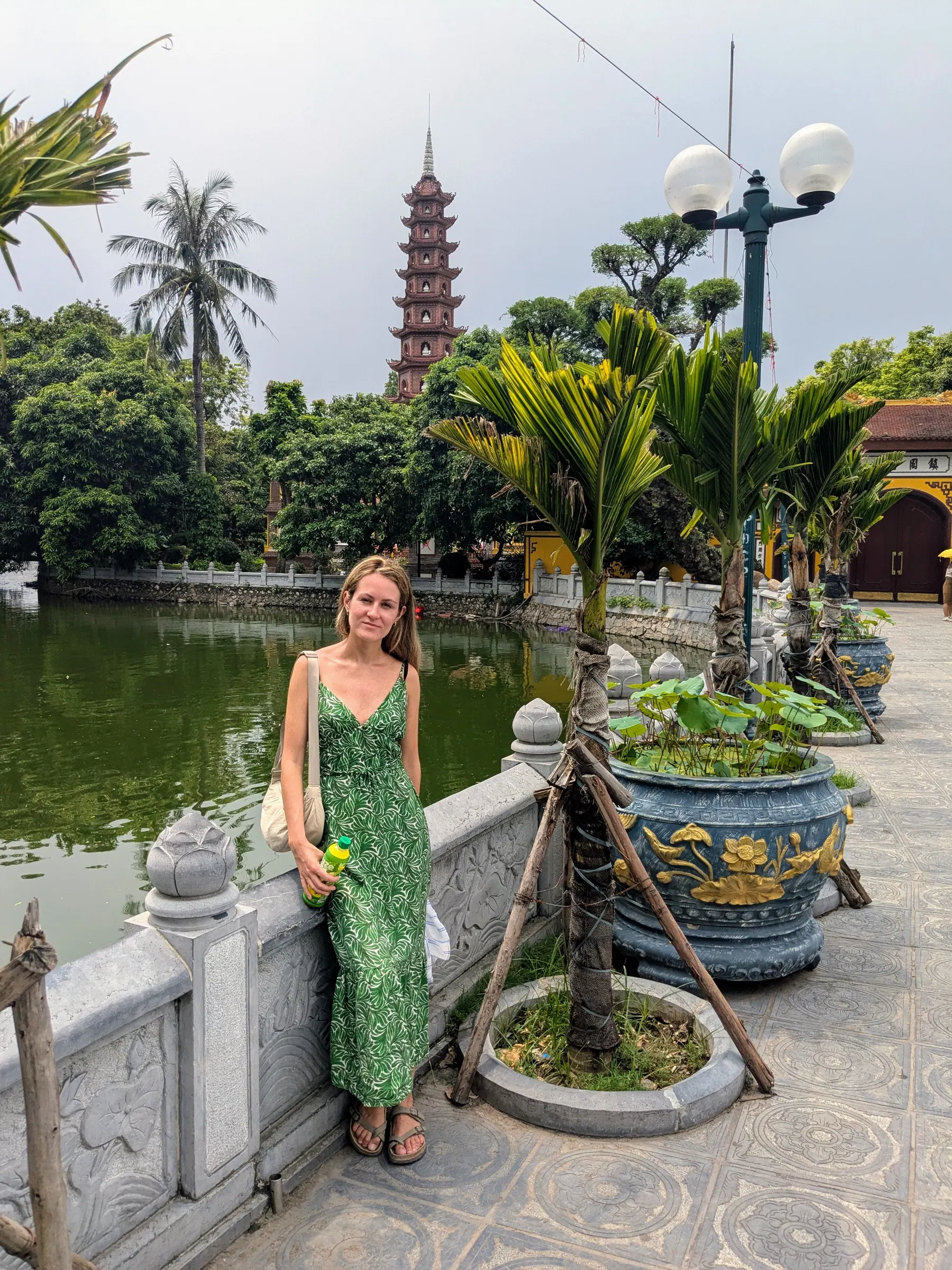 A traveller beside Trấn Quốc Pagoda and its waterside garden