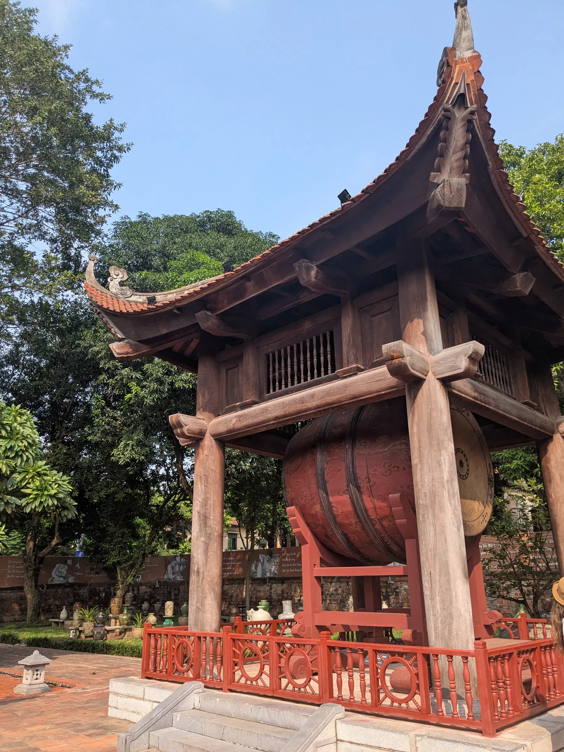 A wooden Hanoi temple with a broad tiled roof and incense altar