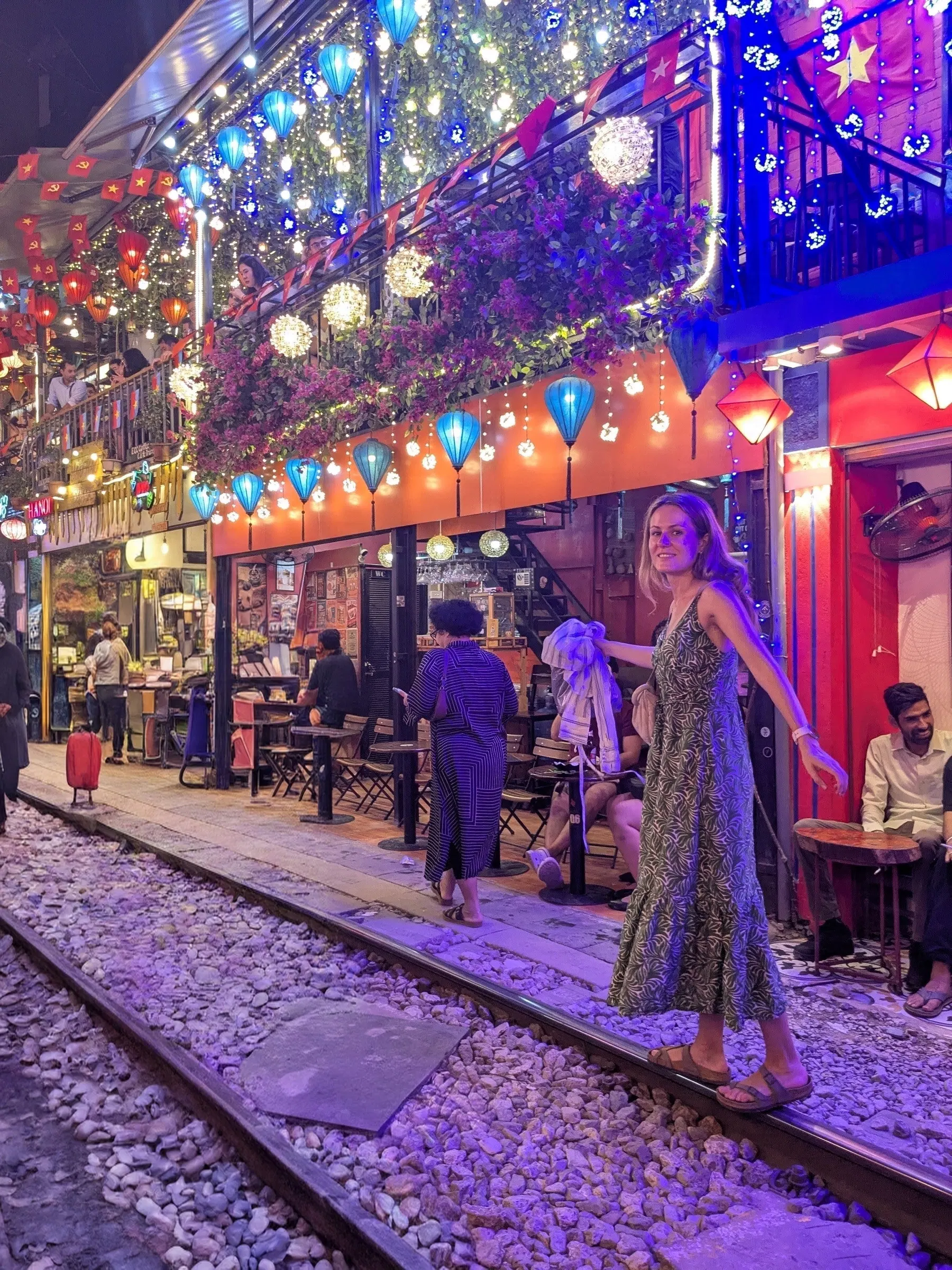 Bright lights and lanterns beside the tracks on Hanoi Train Street
