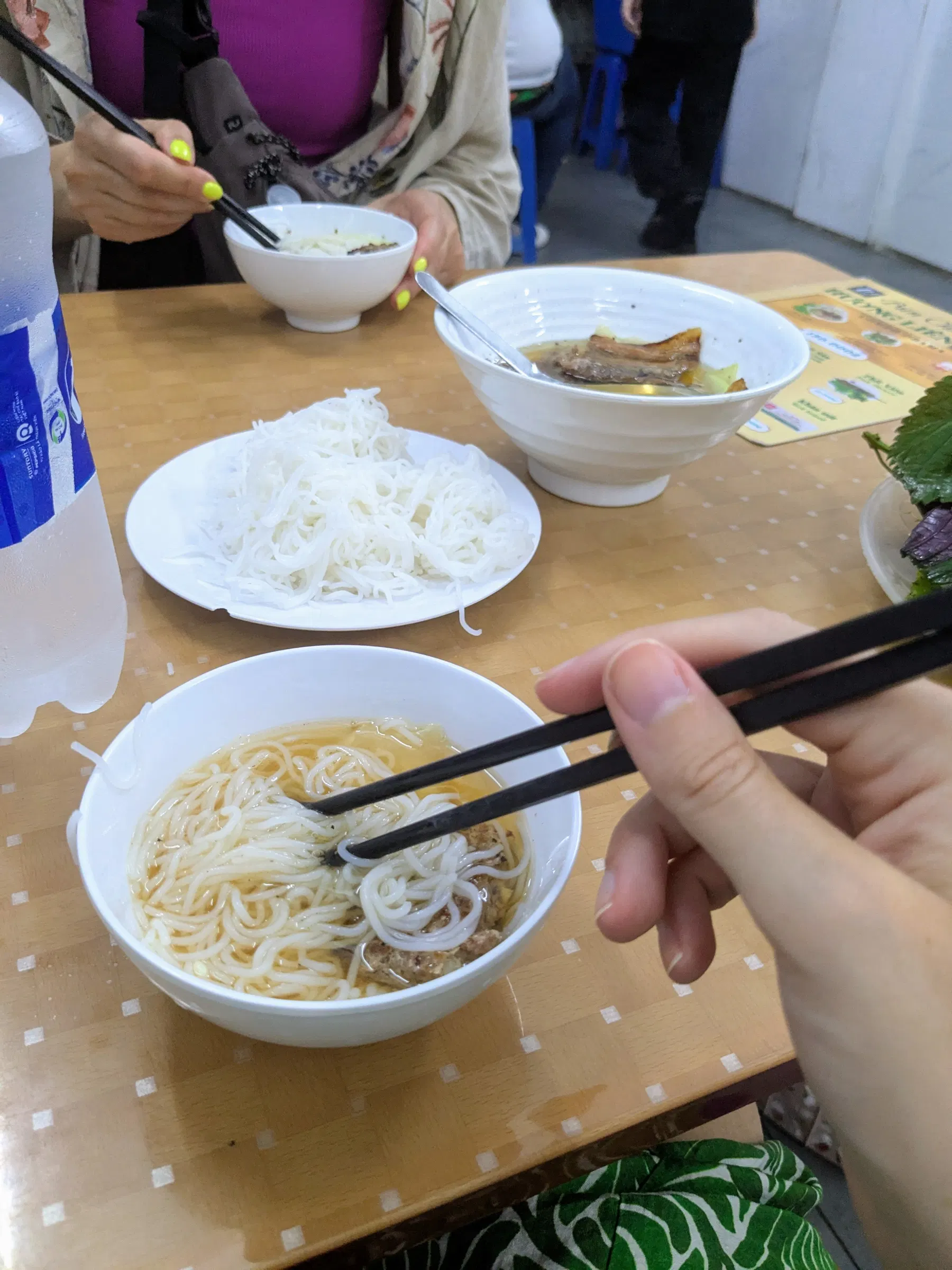 Bún chả with grilled pork, rice noodles and herbs on a Hanoi table