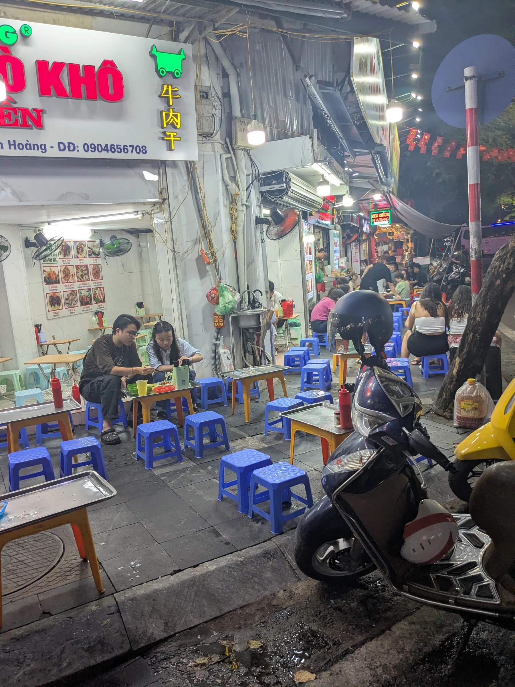 Street-food stalls and low plastic stools in Hanoi after dark