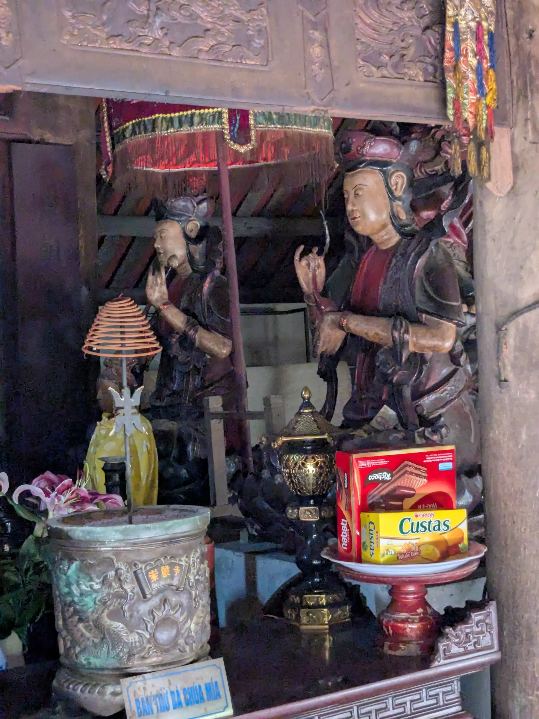 Offerings and carved figures inside an old temple in Đường Lâm village