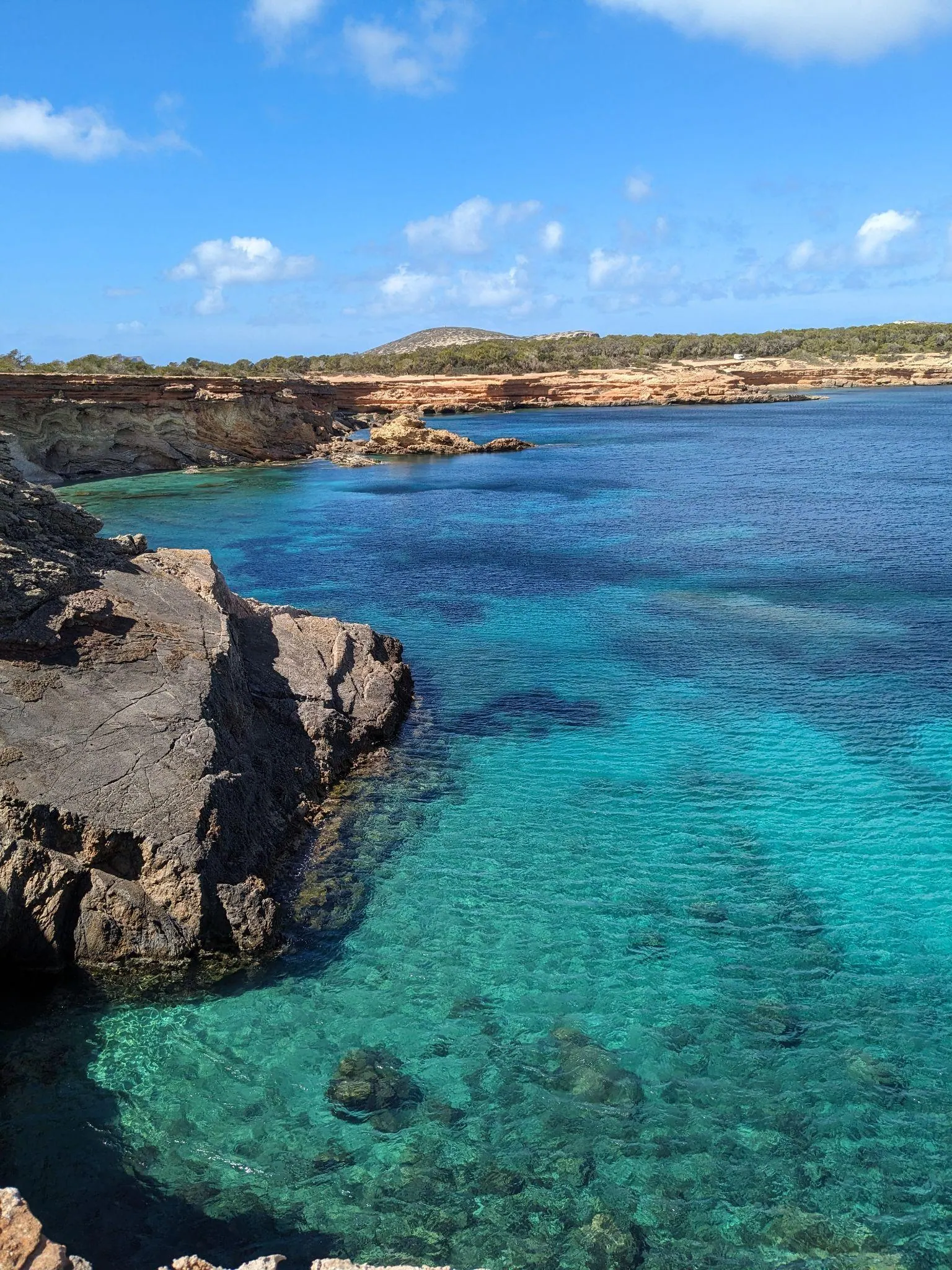 Vibrant blue water over white sand in an empty cove along the west coast