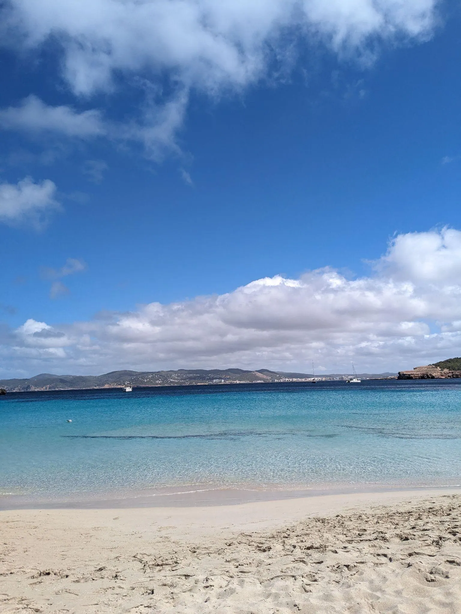 Clear calm shallow waves rippling over sand at the water edge in Cala Bassa