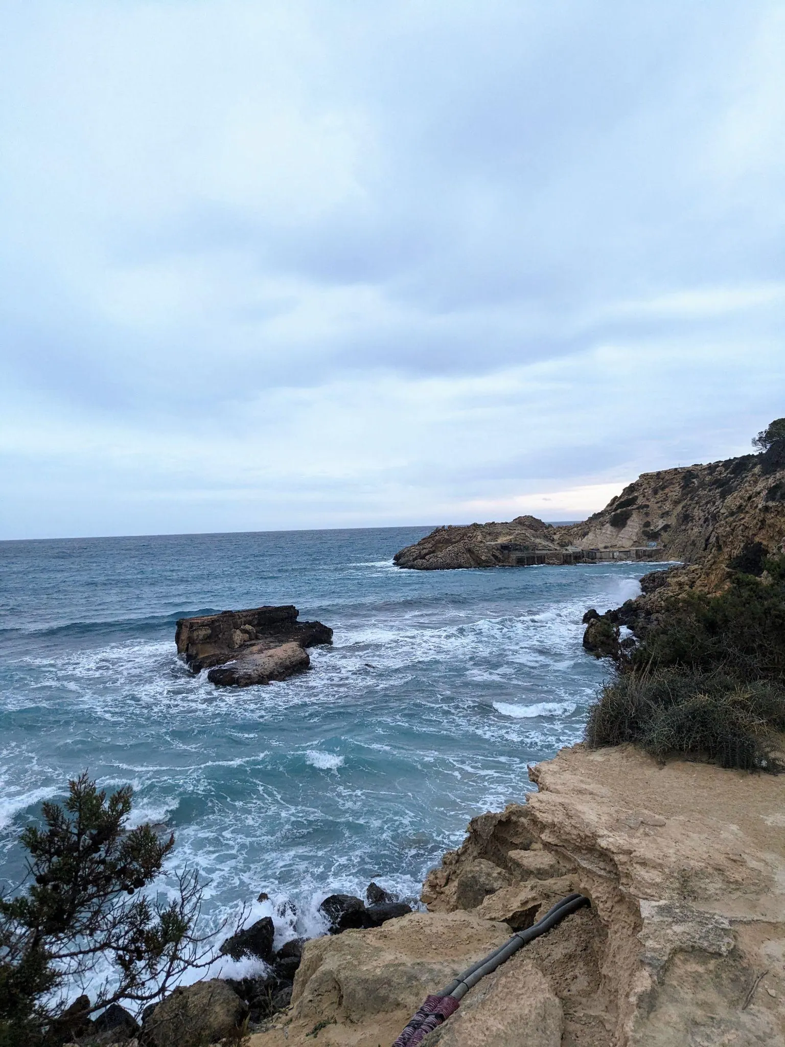 Rugged headland and rocky coastal path overlooking the sea near Cala Tarida