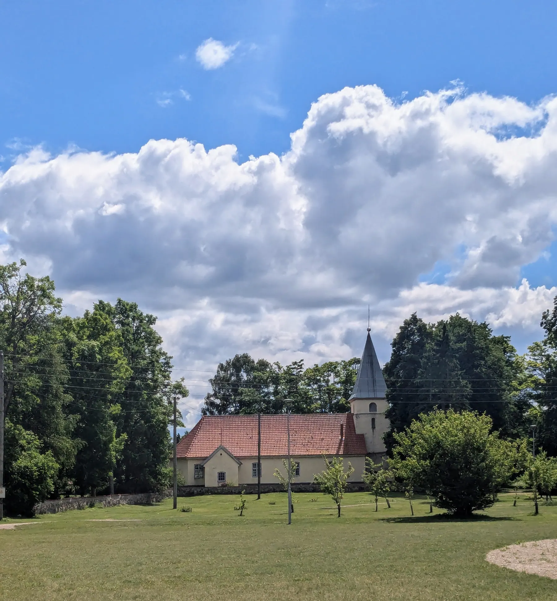 St. Joseph's Roman Catholic Church surrounded by trees in Jūrkalne