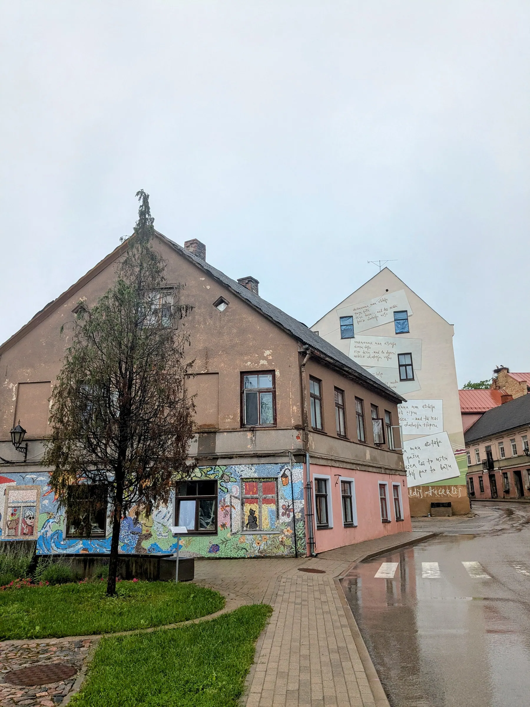 A mosaic-covered corner house and poetry-covered wall in Kandava