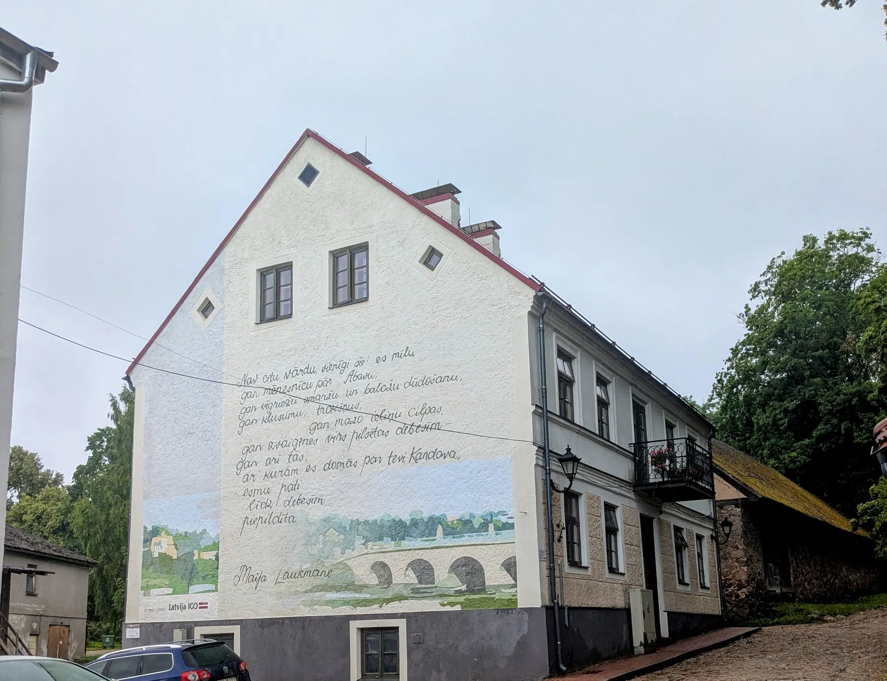 A poem by Maija Laukmane painted across the side of a Kandava house