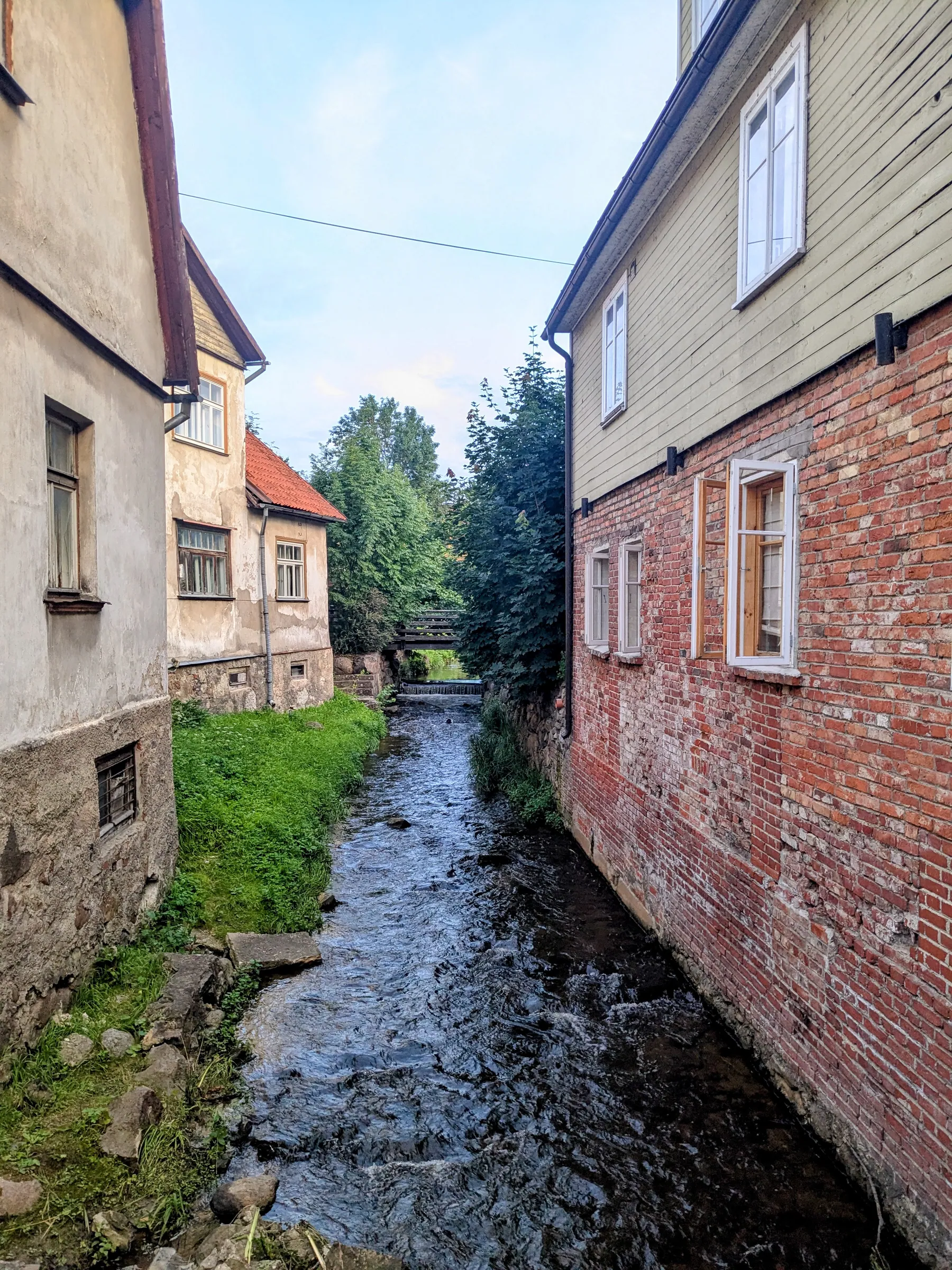 Aleksupīte stream running between historic buildings in Kuldīga