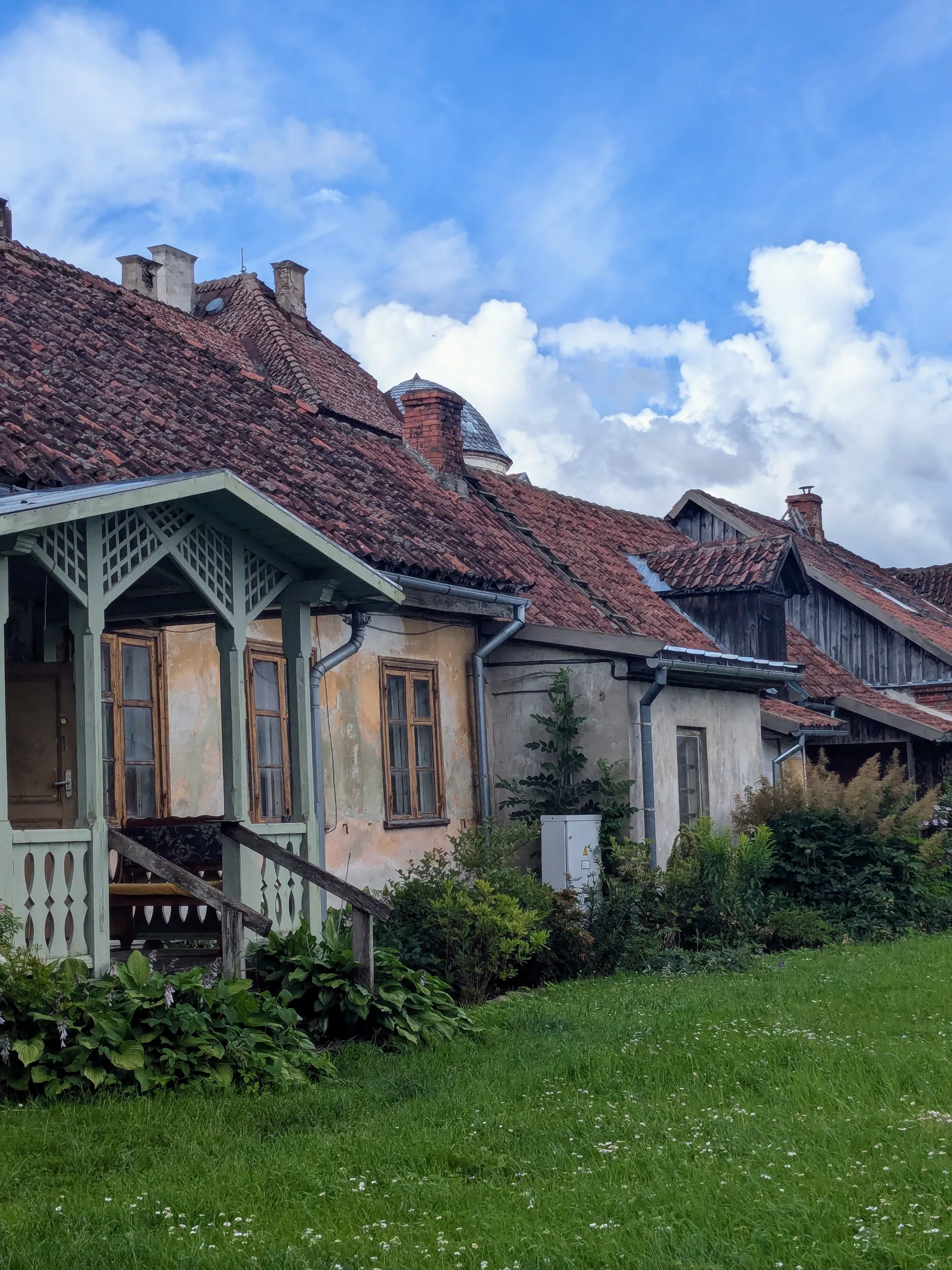 Old wooden house beside a garden in Kuldīga