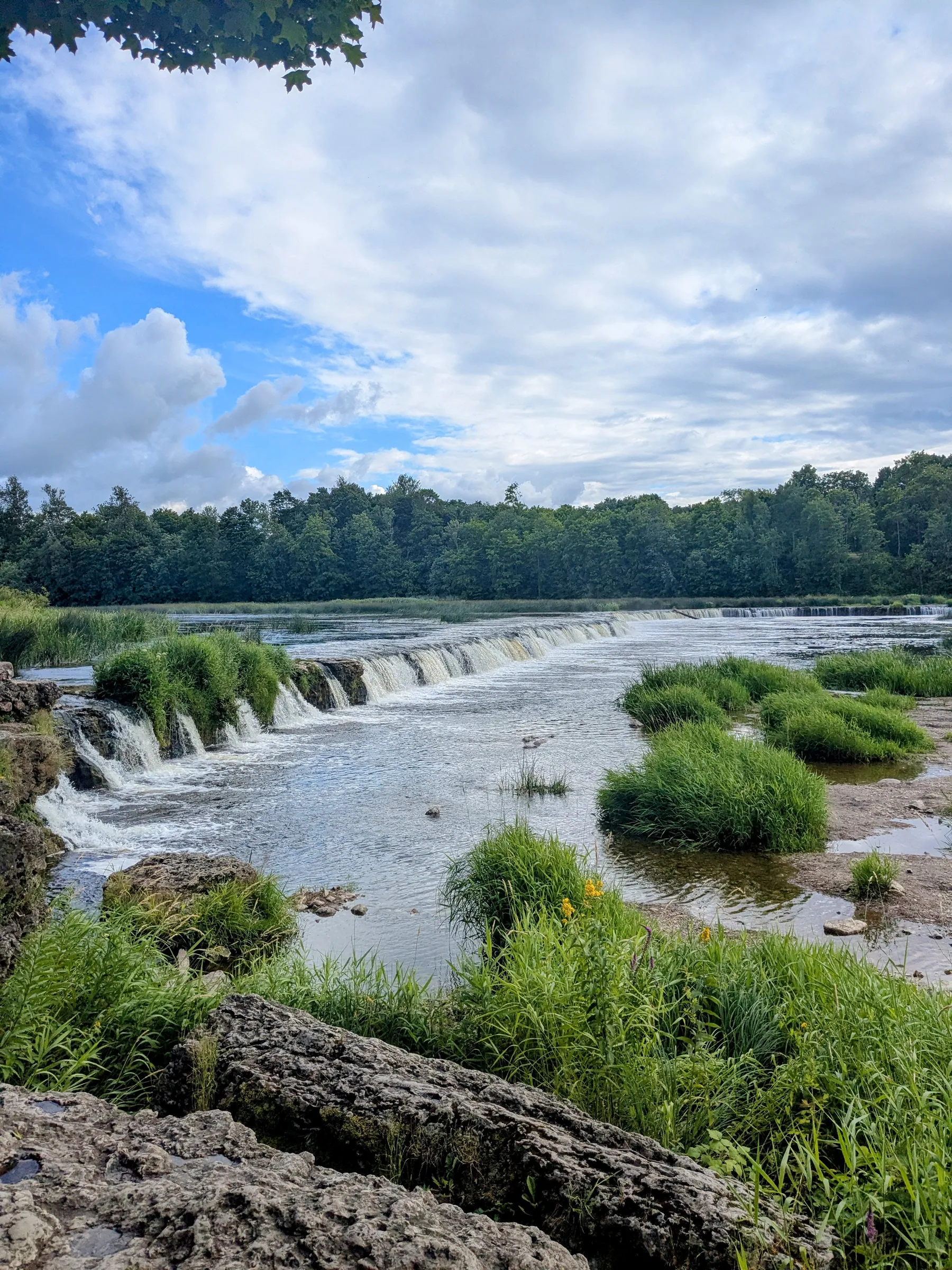 The broad Ventas Rumba waterfall beneath a summer sky in Kuldīga
