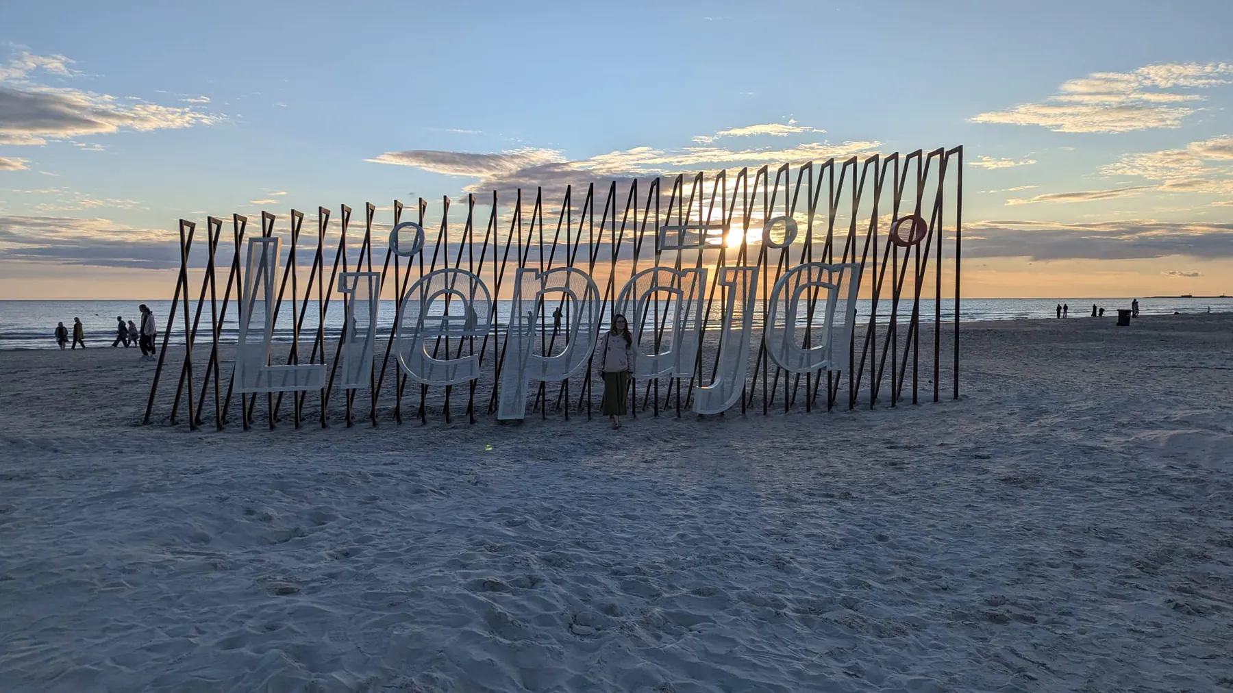 Una instalación de puertas de madera recortada contra el atardecer en la playa de Liepāja