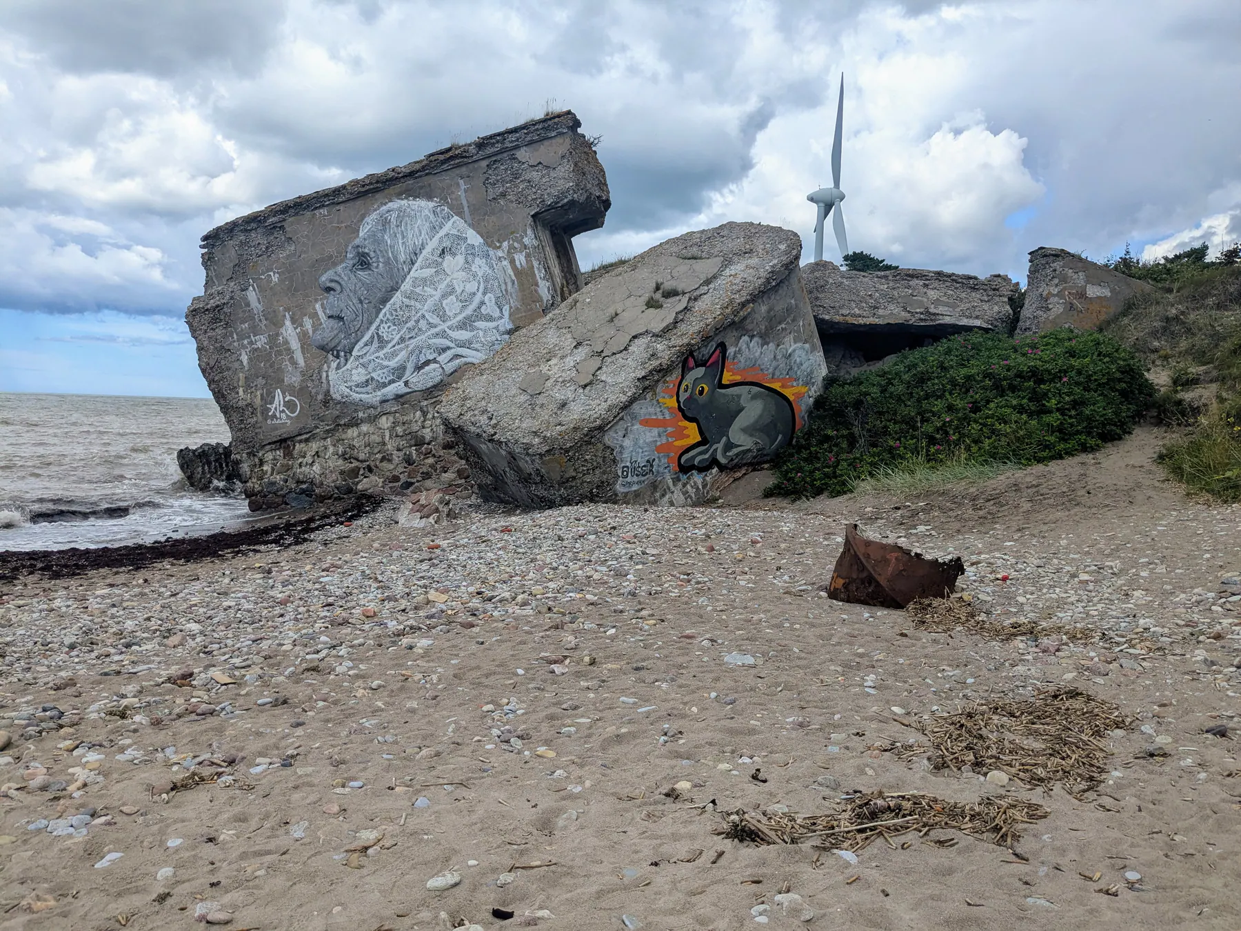 Una losa caída del fuerte cubierta por un gran mural junto a la playa