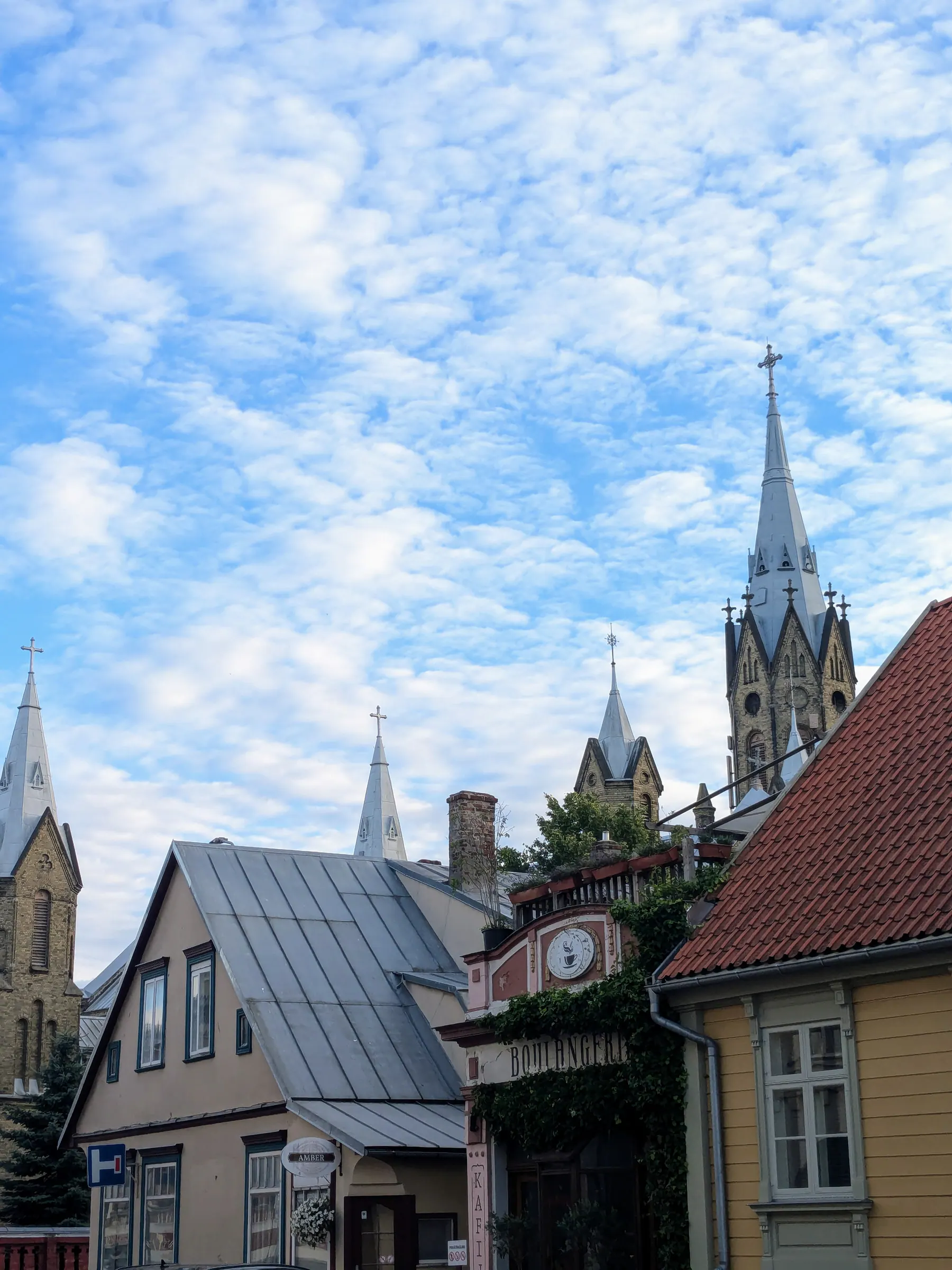 Torres de iglesias sobre casas de madera y ladrillo en Liepāja