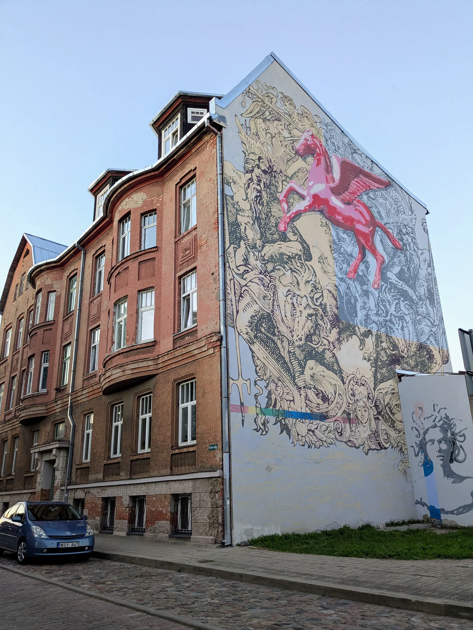 Un gran mural de una mujer y una bicicleta en un edificio residencial