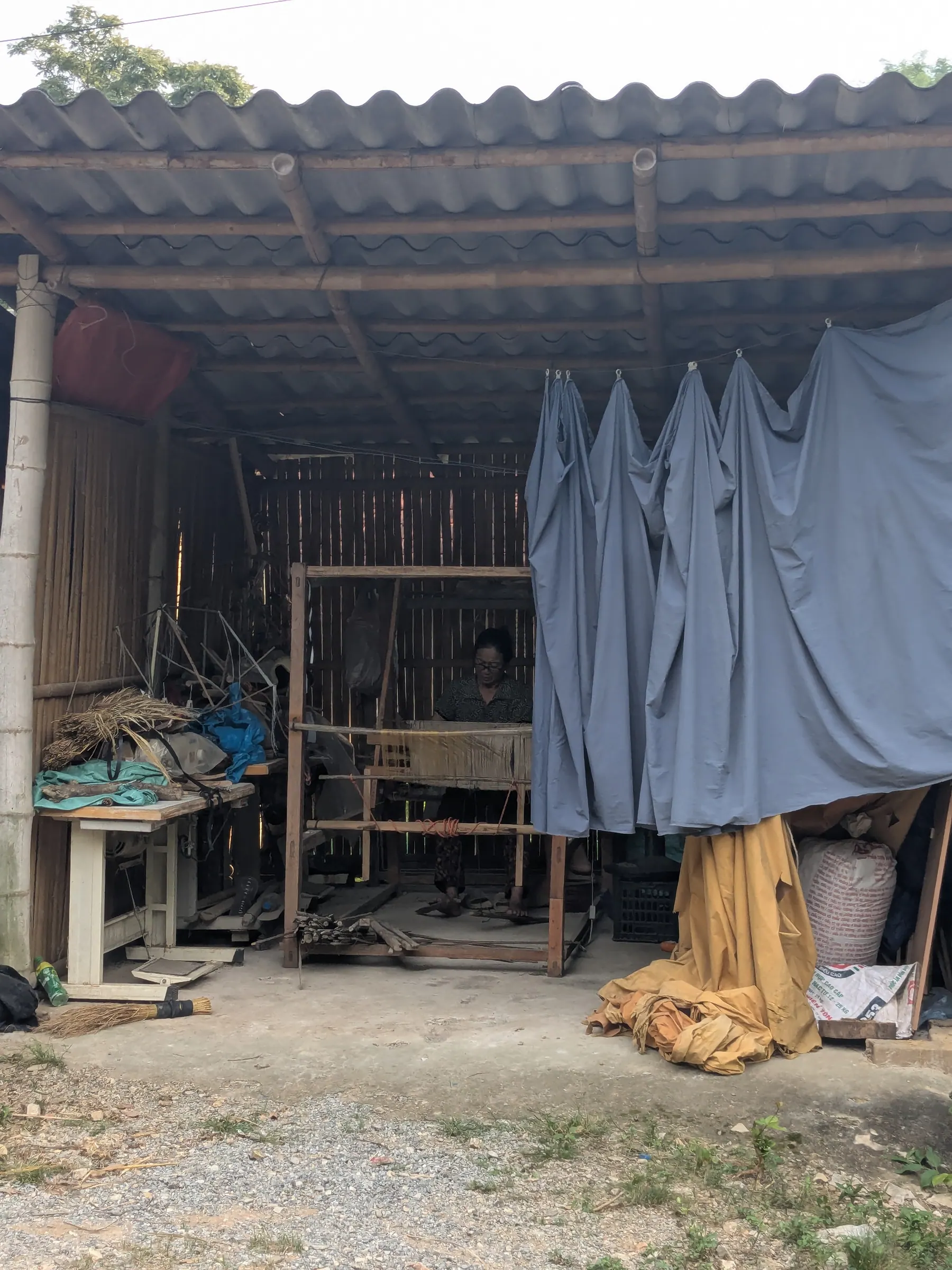 A loom and hanging textiles in a Lac Village workshop