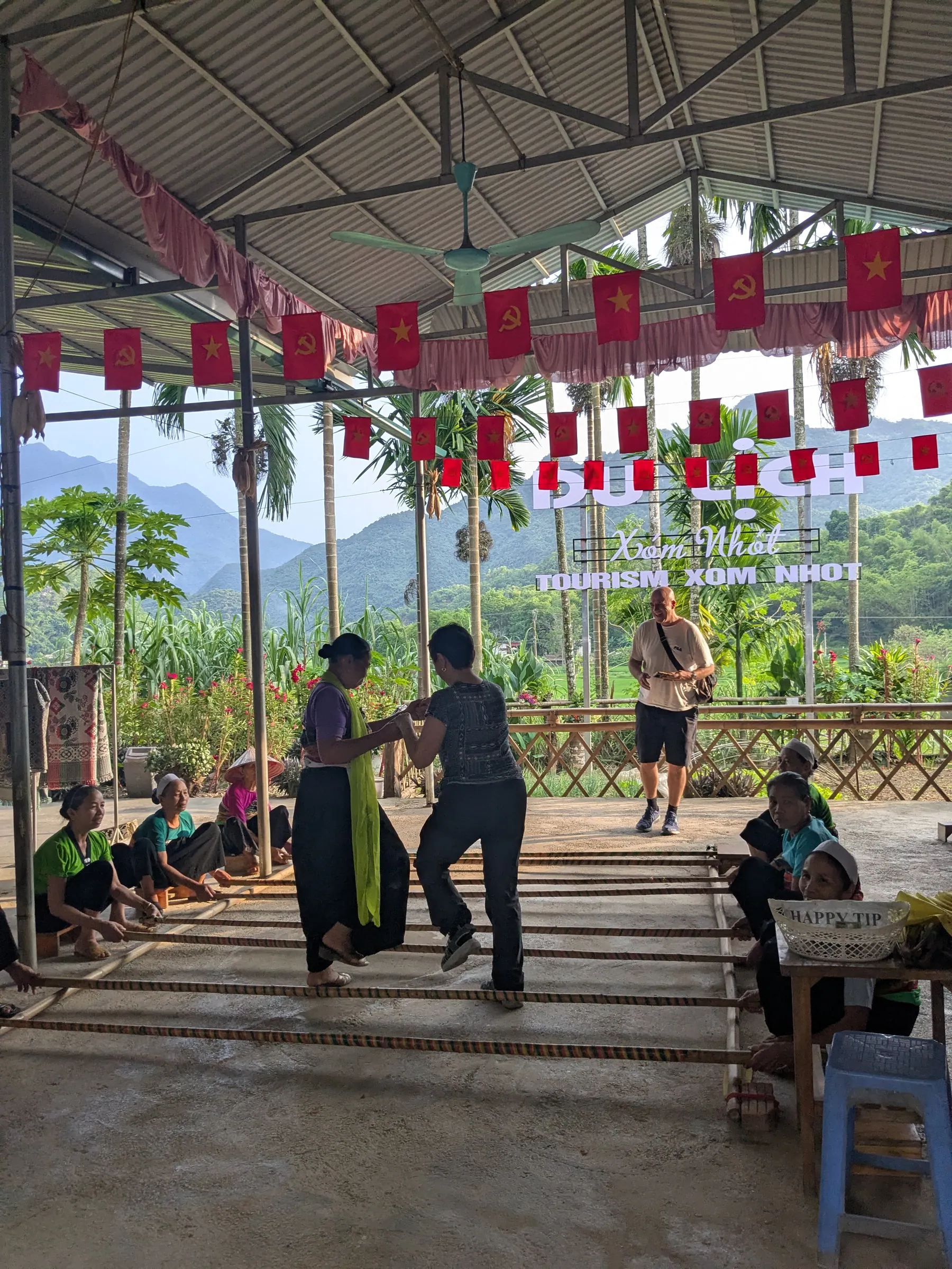 Women performing a cultural dance in a decorated open-sided pavilion in Mai Chau