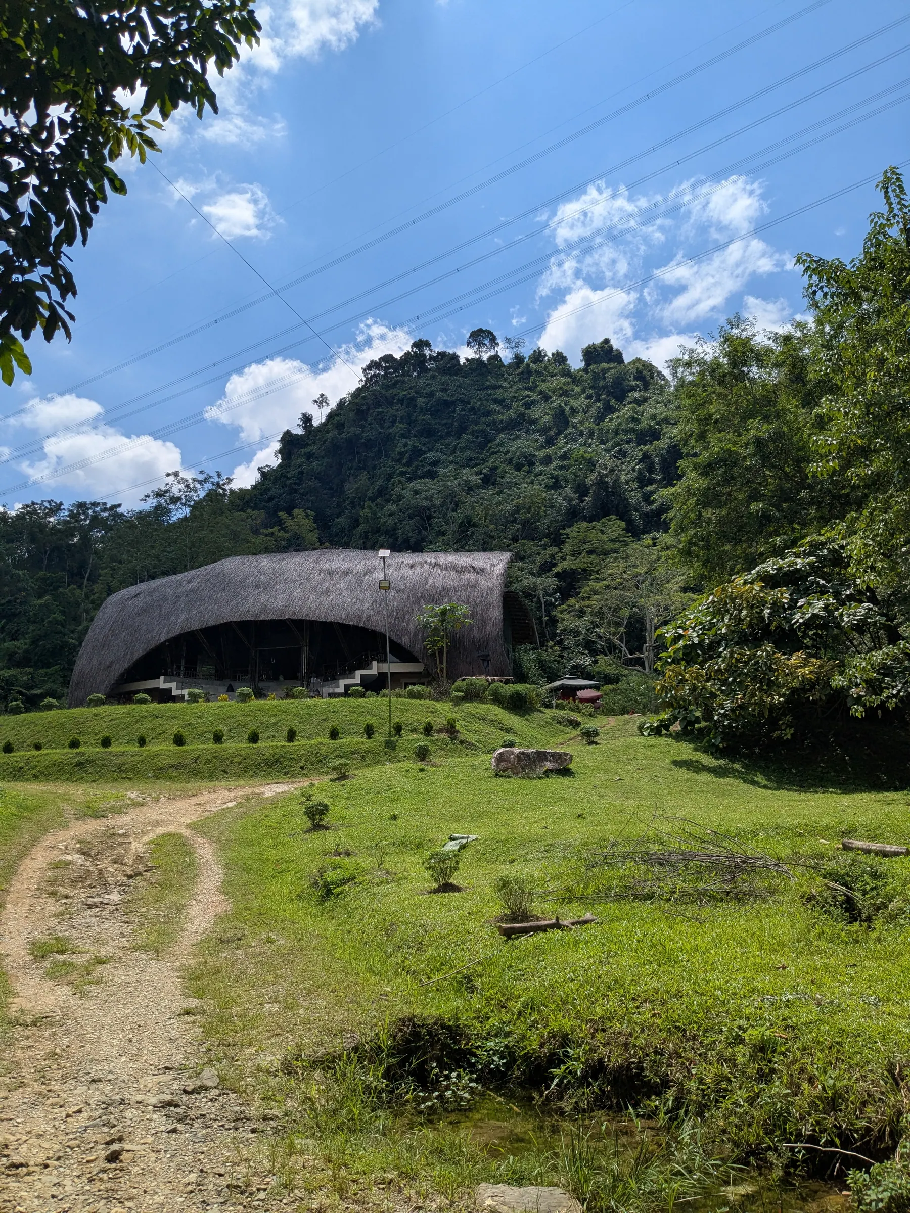 A large concrete structure set in a green valley near Thác Tạt Nàng