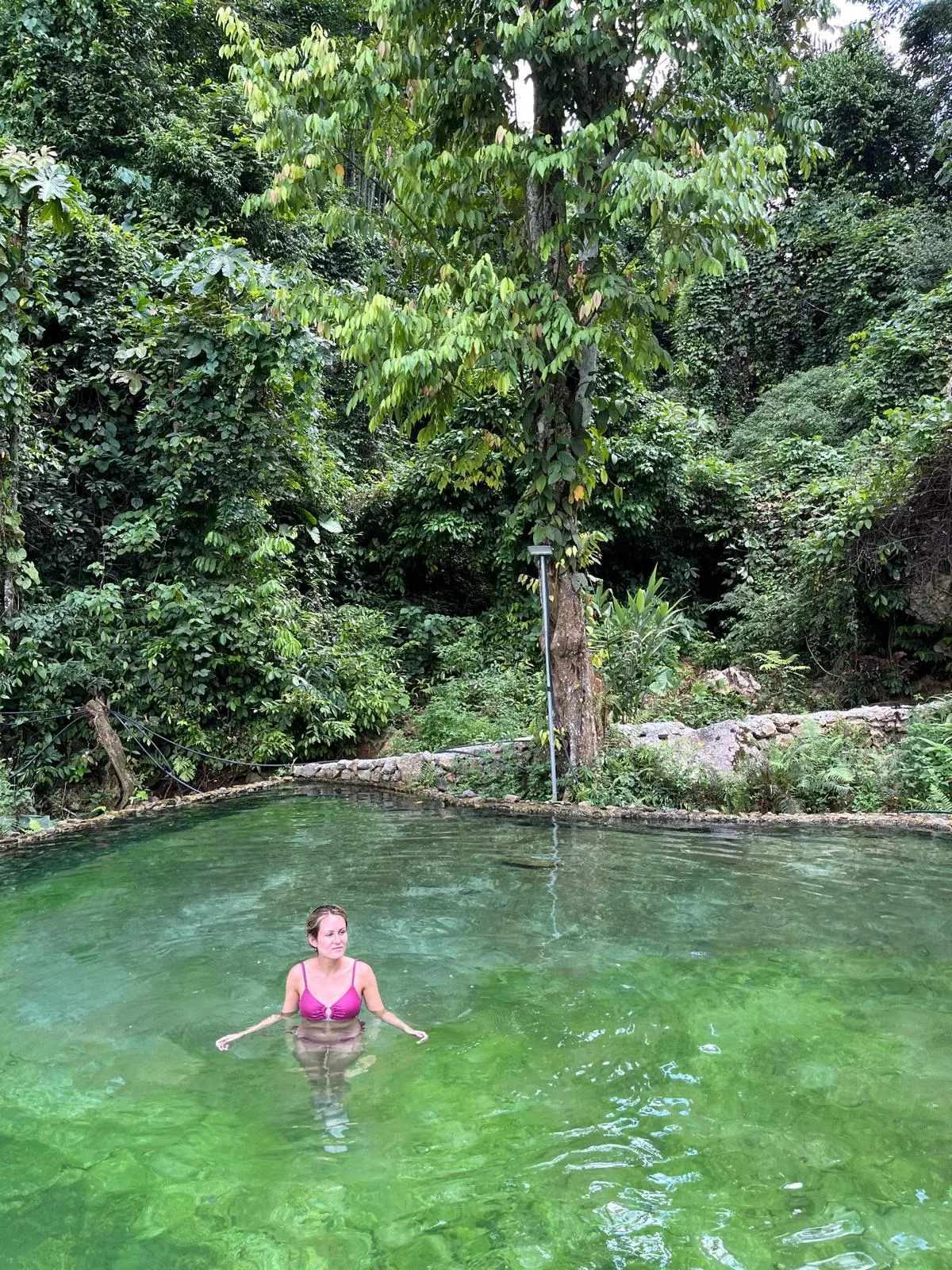 A traveller sitting beside the clear water of Bo Am hot springs