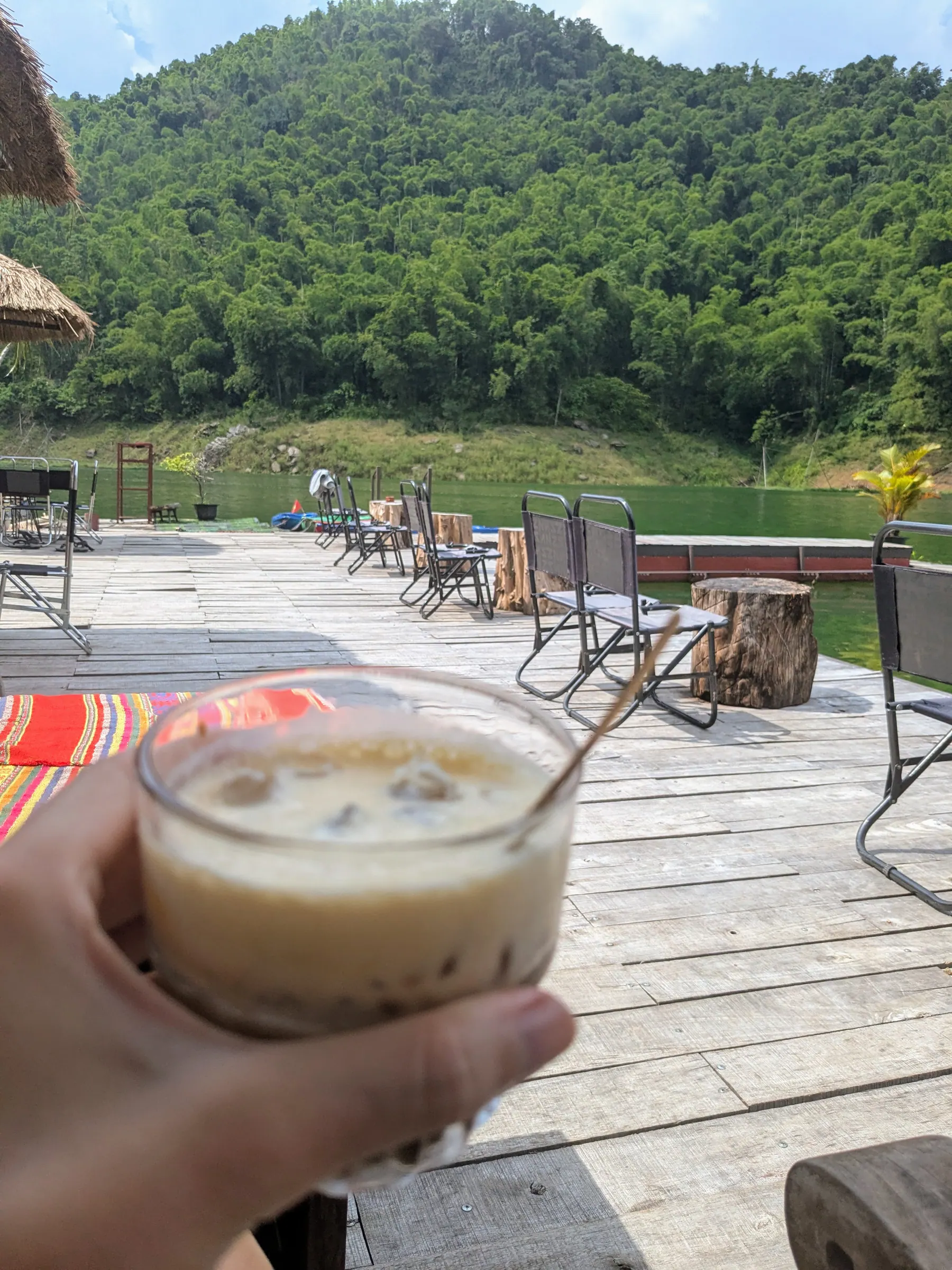 A coconut coffee held over a lakeside terrace